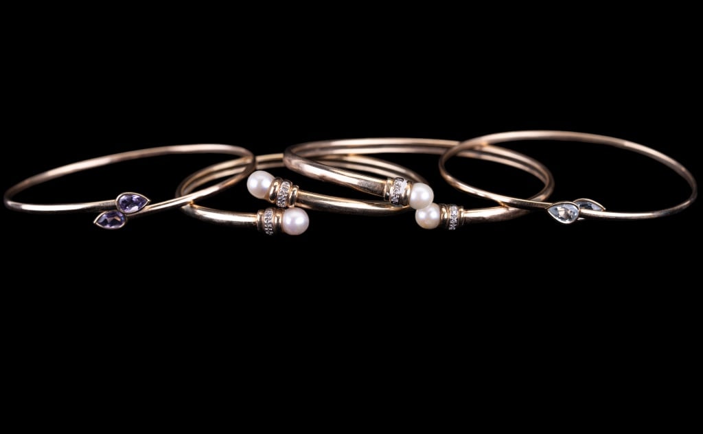 14K Gold Diamond & Semi Precious Bangle Bracelets: Four 14K gold bangle bracelets including 2 with real pearls that are accented with chip diamonds. Two more bracelets include amethyst and blue topaz. Total weight approx 19.5g.