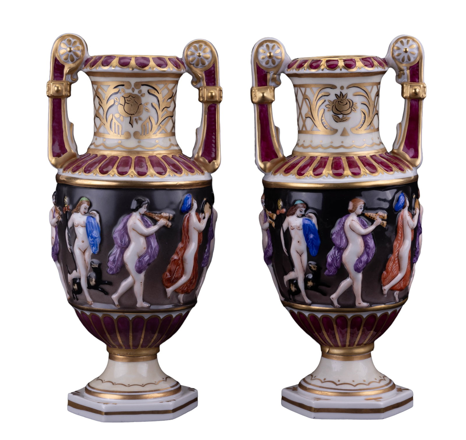 Capodimonte Gilt Urn Pair: Pair of Capodimonte marked urns, both measuring approx 9.5" H. Gilt design of nude women wraps around the handled and footed urns. One urn has an approx 1" crack on the bottom and separation on the "l