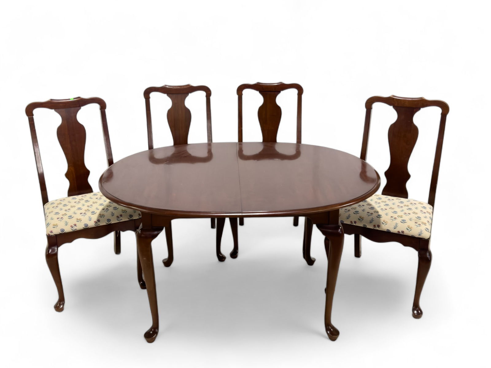 Queen Anne Style Table and Chair Set: Four cushioned queen Anne style chairs and a table of the same style. Chair have a floral upholstery. Measures approx. 41" x 18.5" x 17" (chair). Table measures approx. 29.5" high, 42.25" wide at wide
