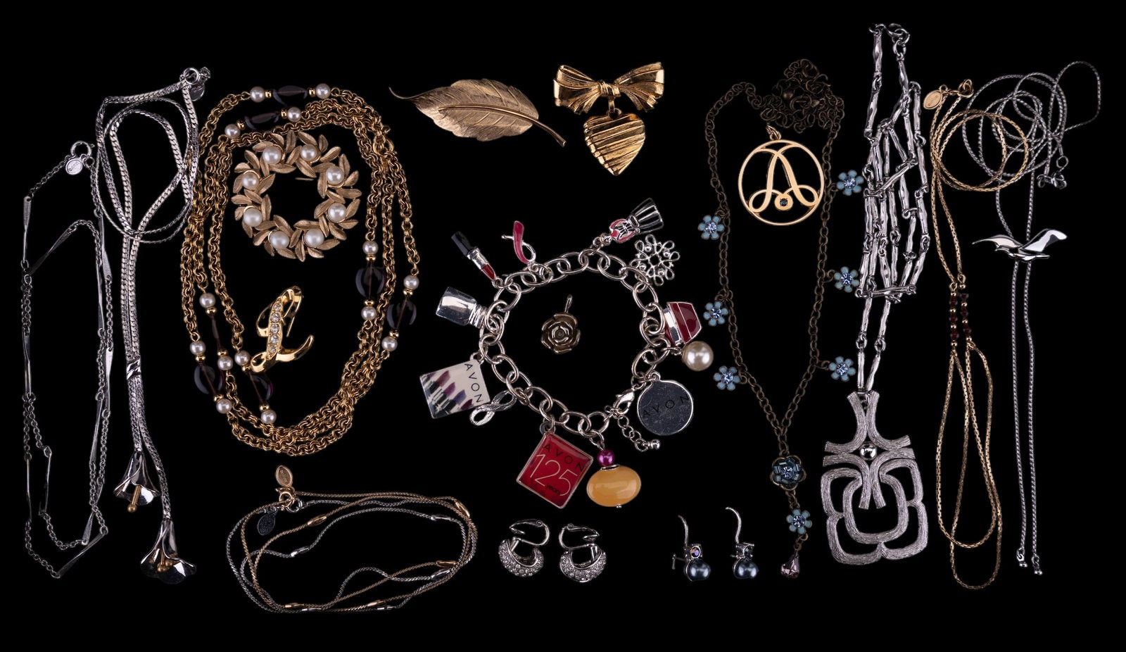 Sterling Avon, Vintage Avon, & Avon: Avon jewelry featuring a 3/4" sterling Avon rose pendant, a 1 1/4" Avon 1/10 10 KGF "A" pendant with rhinestone accent, a vintage wreath brooch wih faux pearls, a 2011 charm bracelet celebrating 125 y