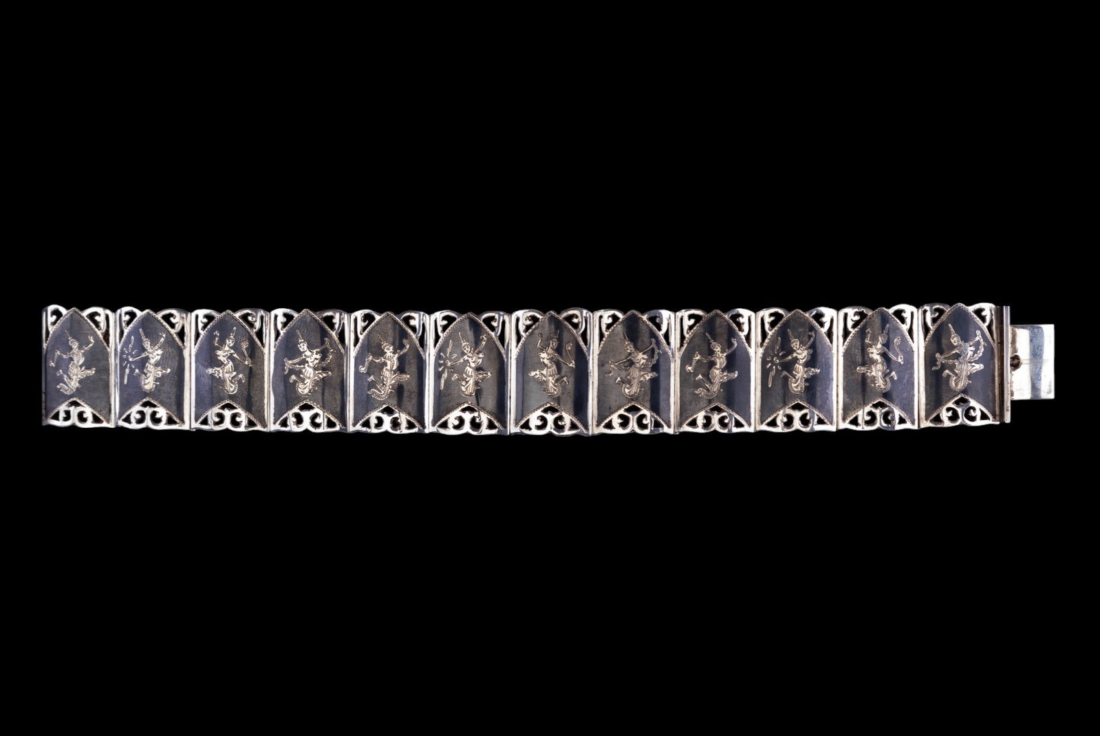 Vintage Siam Sterling Bracelet: This vintage Siam sterling bracelet measures 7 1/8" x 7/8". It features 12 hinged panels that are hand etched with bare breasted dancers and cut work edging. Stamped inside Siam Sterling. 34.18 grams.