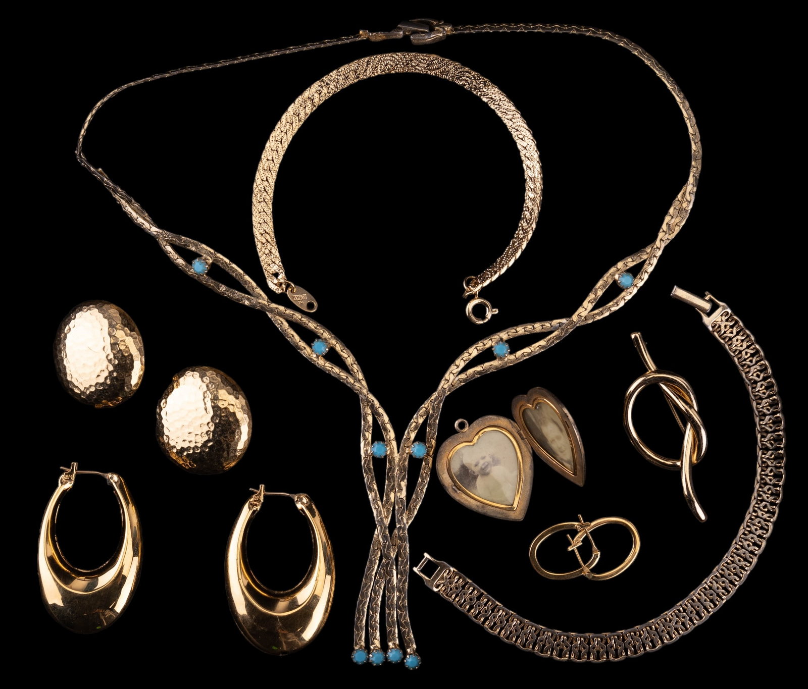 Vintage Goldette Necklace & Brand Name Jewelry: A vintage Goldette NY 17" lariat style necklace with faceted and pronged turquoise colored glass accents, a 1 1/4" P & K (Pittman & Keeler) heart locket, a 2" Napier open knot pin, a 7 1/2" Trifari se