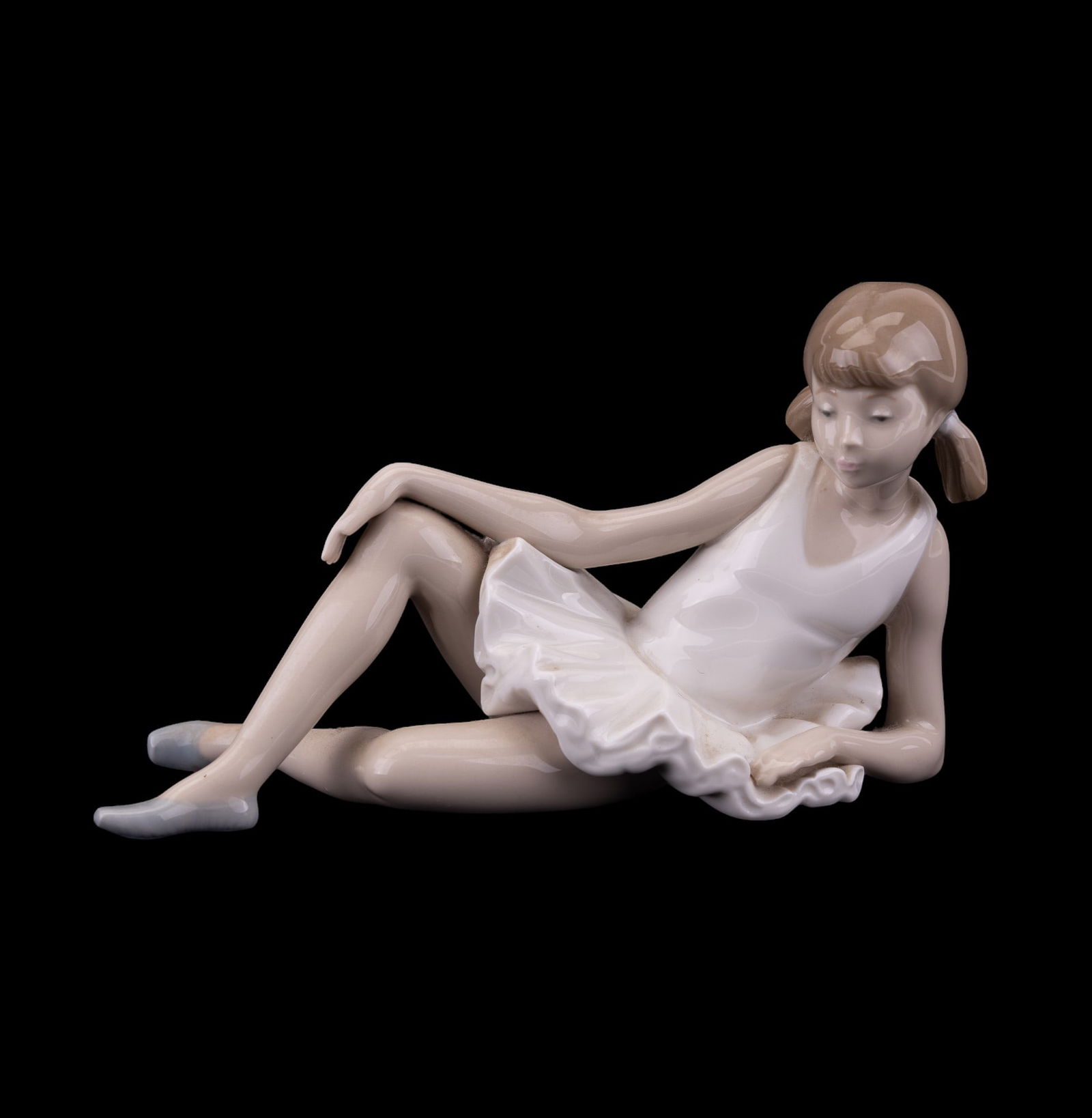 NAO Spanish Ballerina Figurine: NAO made in Spain marked hand painted Llladro reclining ballerina figurine. Measures approx 8.5" L x 4.5" H.