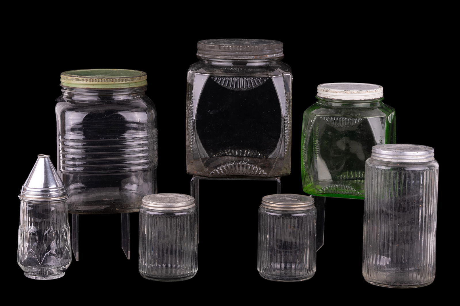 Antique Hoosier Cabinet style Glass Cannisters: Antique Hoosier Cabinet style Glass Cannisters. Seven pieces: 6 antique cannisters, 1 vintage sugar dispenser. Tallest cannister is 8" tall.