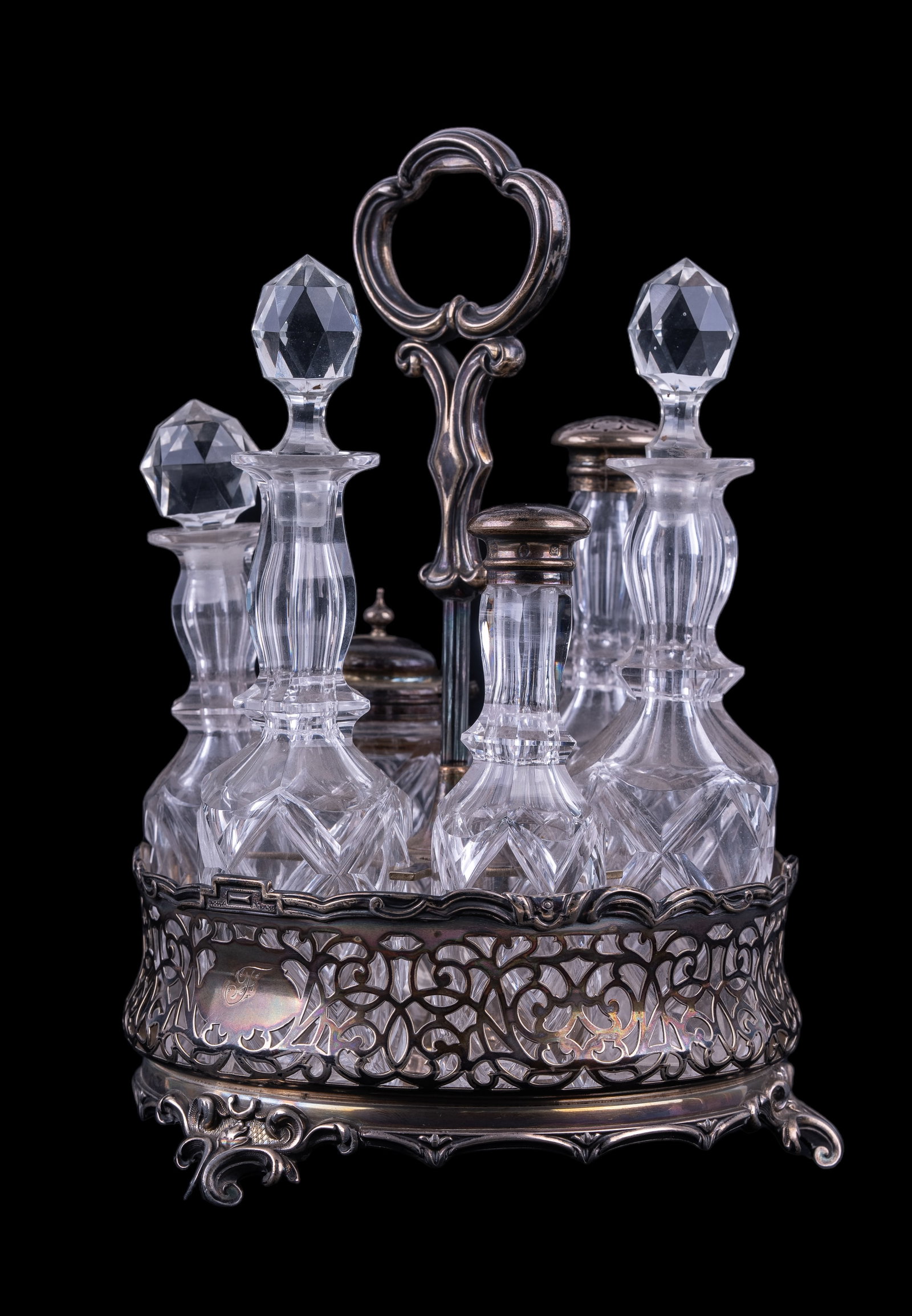 Antique Cut Glass and Silverplate Condiment Stand: Includes 6 pieces of cut glass condiment bottles with silverplate lids and stand measuring approx. 10.5" H x 7.5" dia.