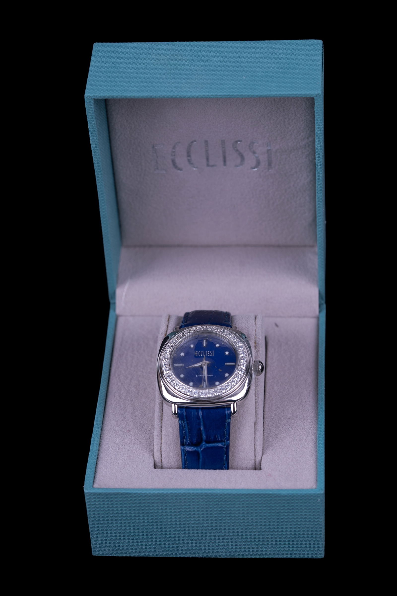 Ecclissi Sterling Silver Designer Watch: Ecclissi sterling silver cased watch with crystal detail and blue leather strap in unused condition in original box. Untested.
