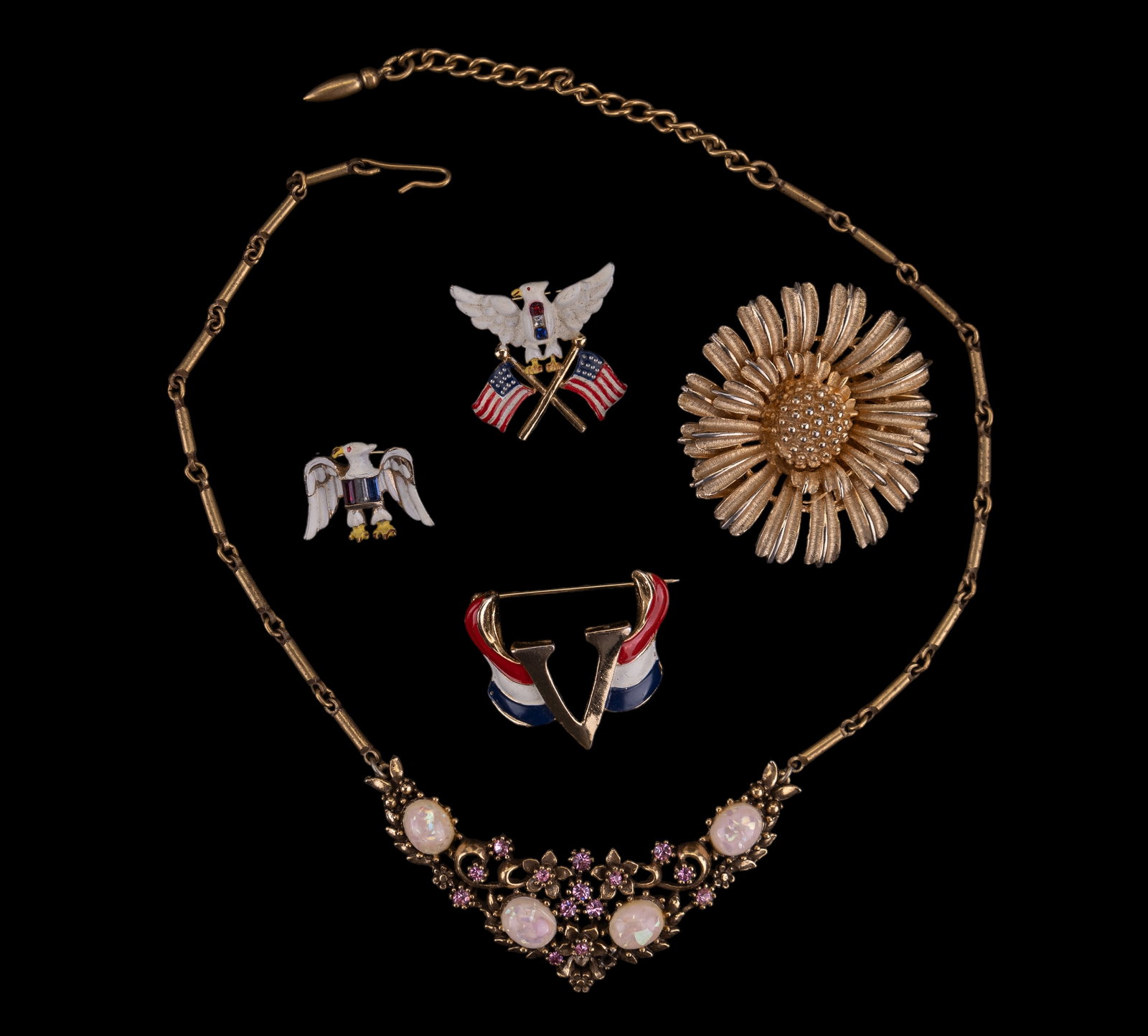 Vintage Coro Jewelry: 5 pieces of signed Coro including a fashion necklace measuring approx. 17.5", 3 patriotic brooches, and gold tone floral brooch.