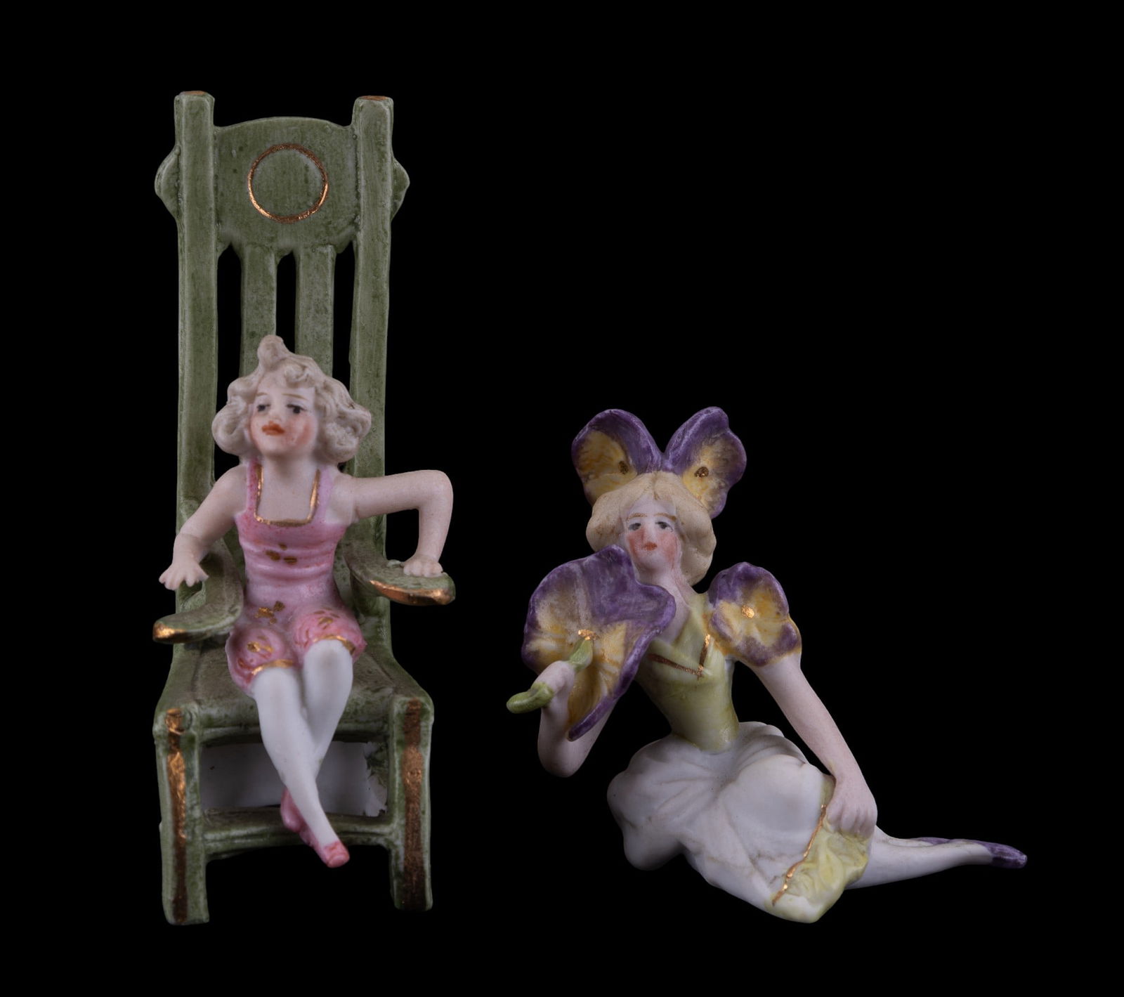 German Bisque Lady Figurines: Woman in pink undergarment sitting on highback chair that measures approx 3.5" tall & woman w/ orchid floral accents sitting down, measuring approx 2" tall.