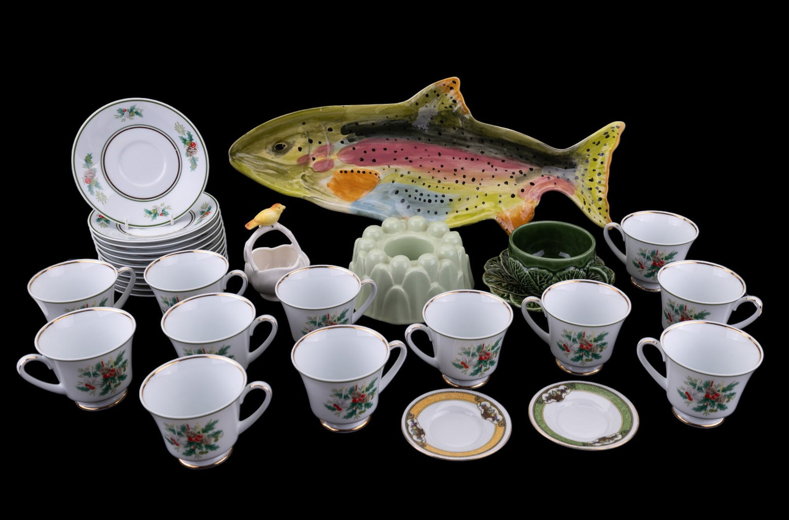 Noritake + Decorative Pottery: 23 pieces of Noritake "Holly" pattern (11 saucers & 12 cups), a Pickle Girl figural fish platter, a cabbage cup with saucer, green Jello mold, a bird basket, and two Farberware German saucers.