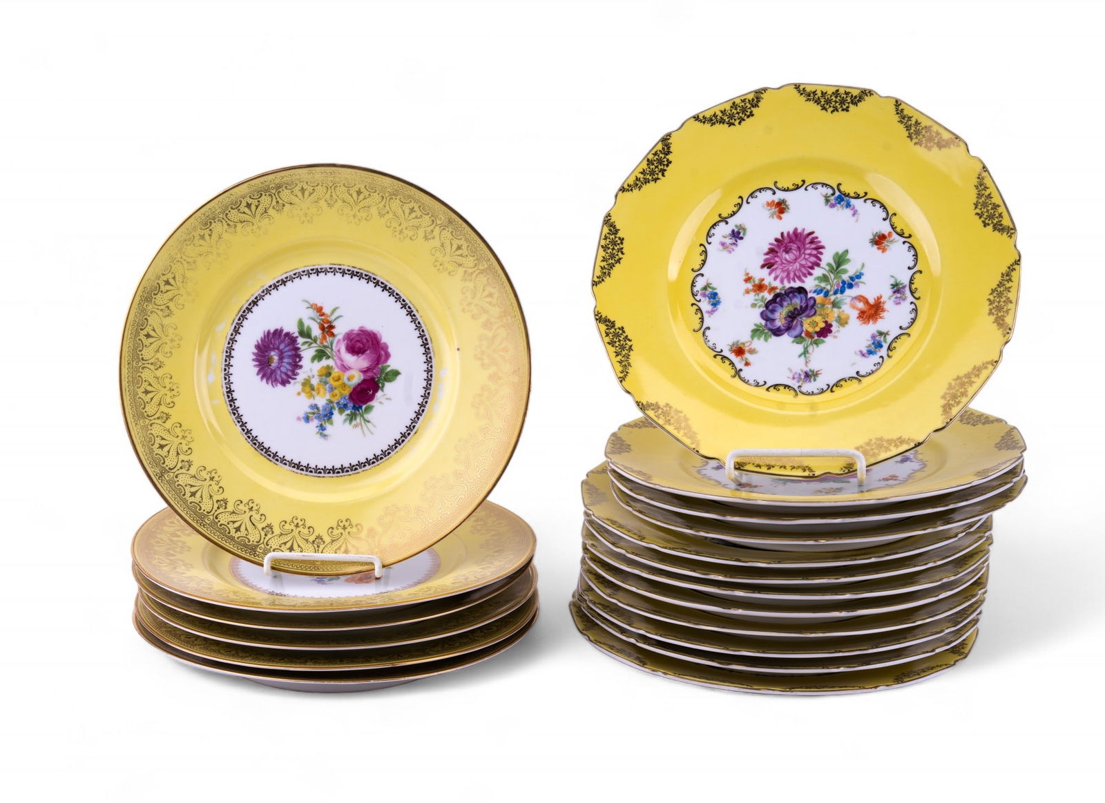 R&M Co. Czech Vintage Plates (18 Pc.): Grouping of eighteen R&M Co. dinner plates, including six non-scalloped 10.5" plates and 12 scalloped 11" dinner plates. Some glazing imperfections present. Pattern has a yellow rim, with a window in