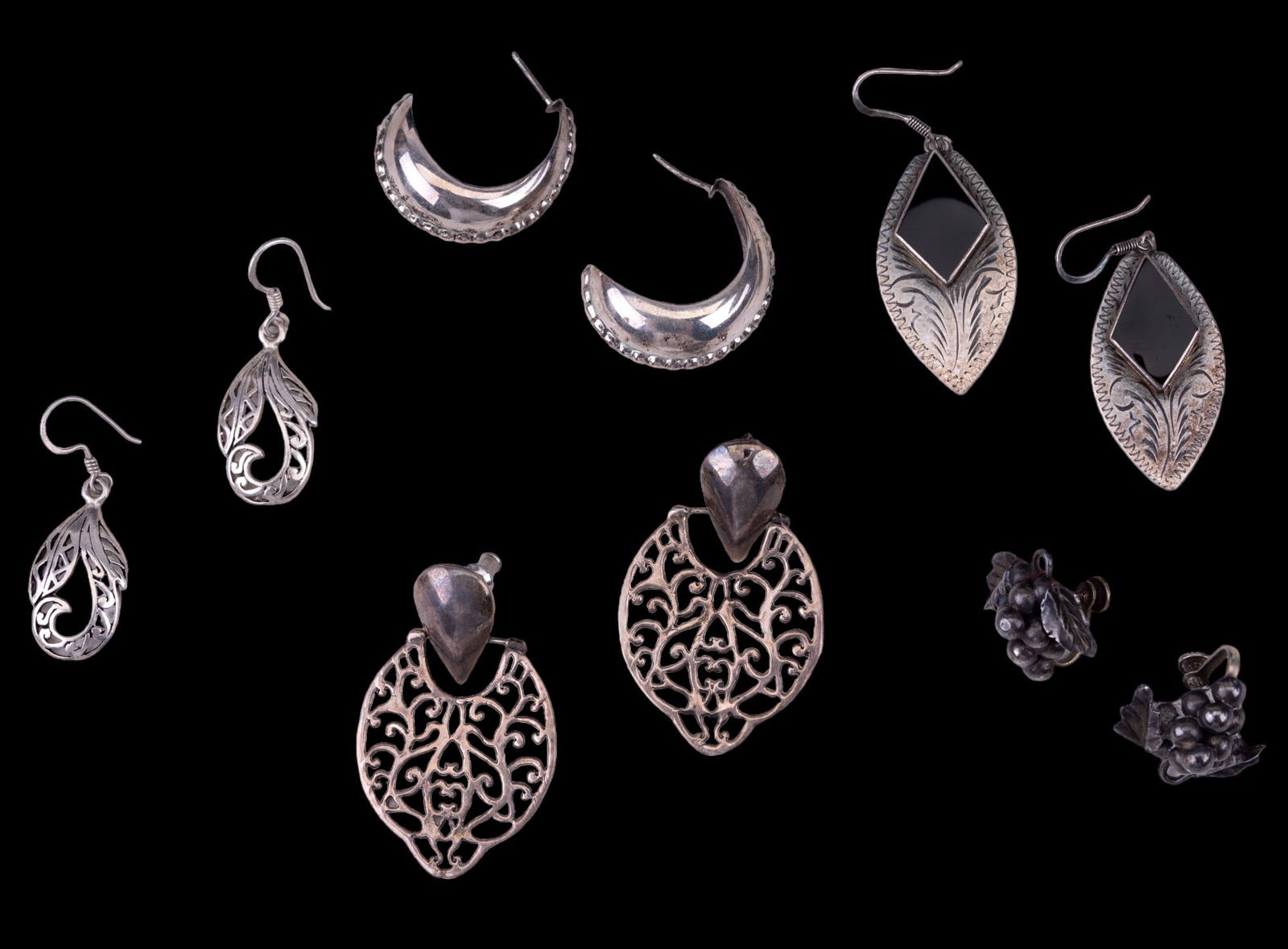 Sterling Earrings (5 Pairs): 5 pairs of sterling silver earrings of various designs. Curved pair was made in Thailand, grape screwback earrings are Plata Aaron Taxco earrings from Mexico, heart motif earrings are unmarked, leaf e