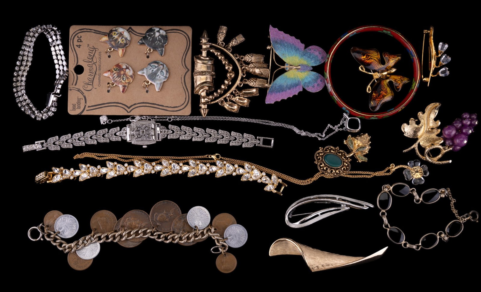 Swarovski Coin Bracelet and Vintage Jewelry: Highlights include Trifari gold tone swirl brooch, butterfly, and other brooches, 3 Swarovski signed including lily of the valley floral pin, green faceted crystal pendant necklace, and crystal four l