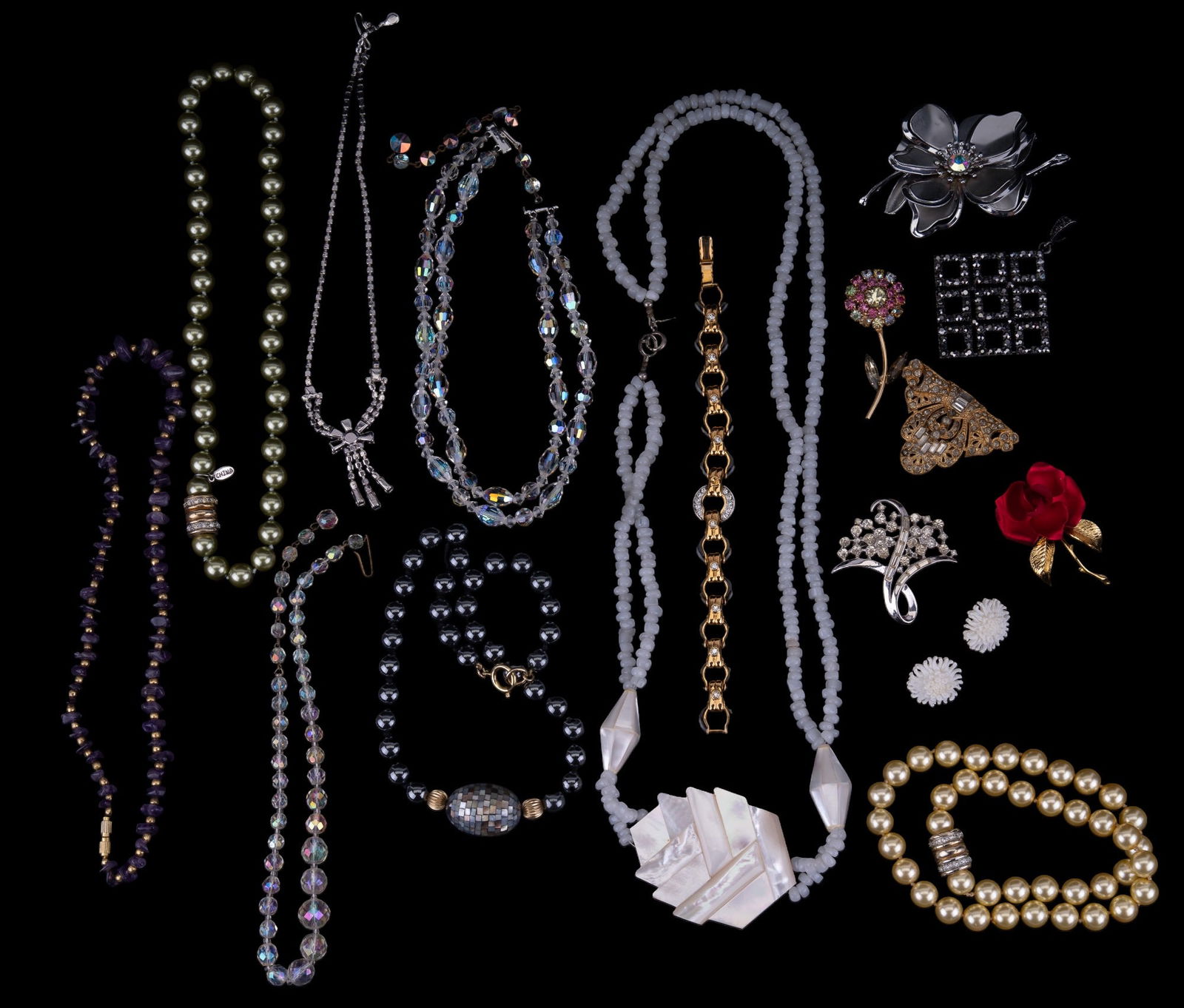 Vintage Estate Jewelry: Various vintage jewelry to include signed Karla Jordan shell necklace, amethyst crystal, and pearl style necklaces, pins and brooches, rhinestones, and more.