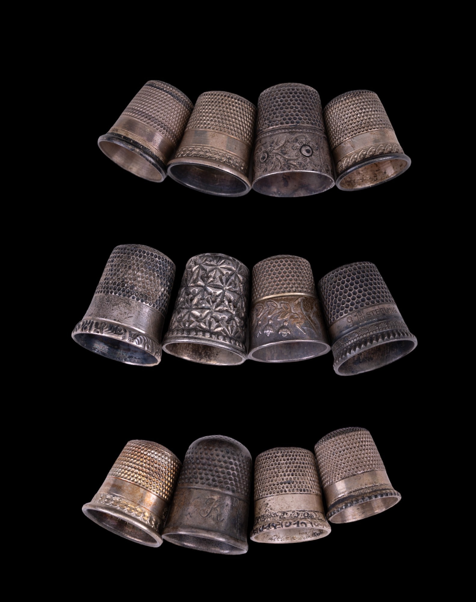 Sterling Silver Thimbles (12): Twelve sterling silver thimbles with different designs, many with engraved patterns near bottom of thimbles & more. Total weight of grouping is approx. 42.4 grams.