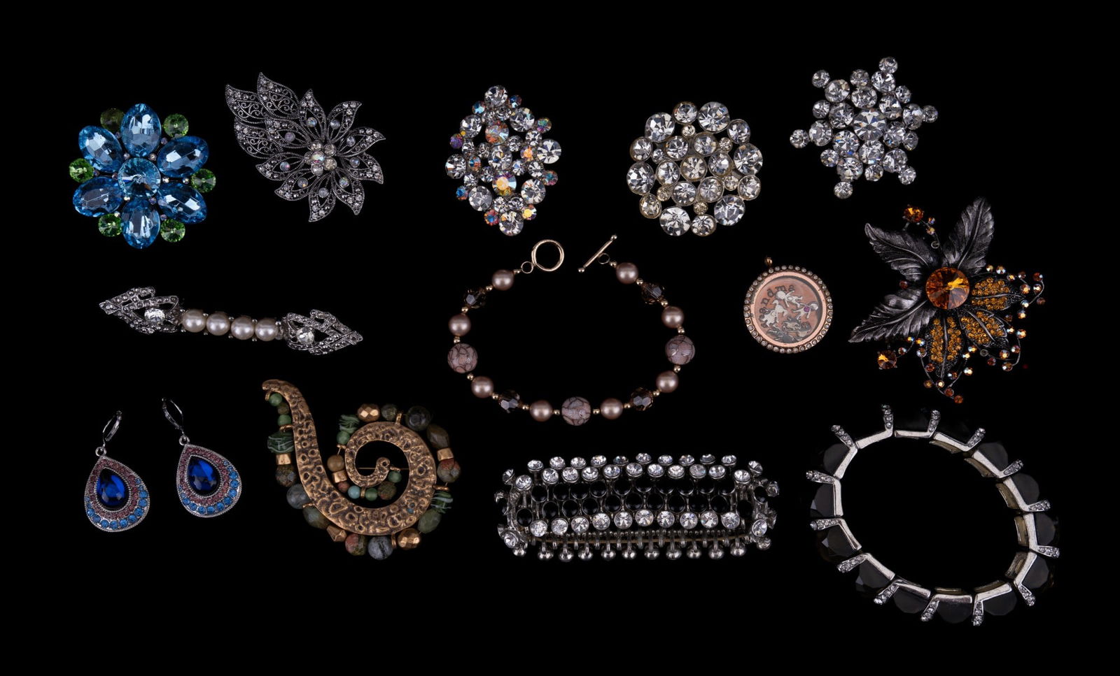 Rhinestone Brooches, Earrings, more: Grouping consists of: Seven rhinestone brooches, crystal glass bracelet, two rhinestone cuff bracelets, Monet blue stone rhinestone drop earrings, a crystal gold tone brooch & more.