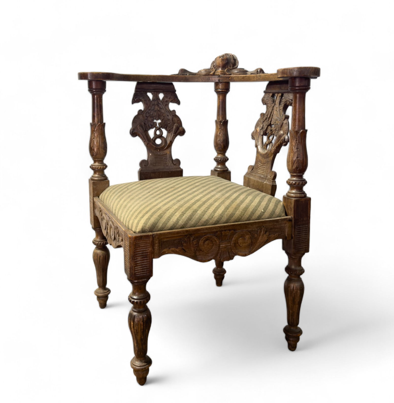 Antique Highly-Carved Cherub Corner Chair: Antique intricately-carved corner chair w/ carved cherub head on corner & floral accents on arms. Bird carvings are present on chair backs. Item measures approx 29? tall, seat is approx 18?x18? & 15?