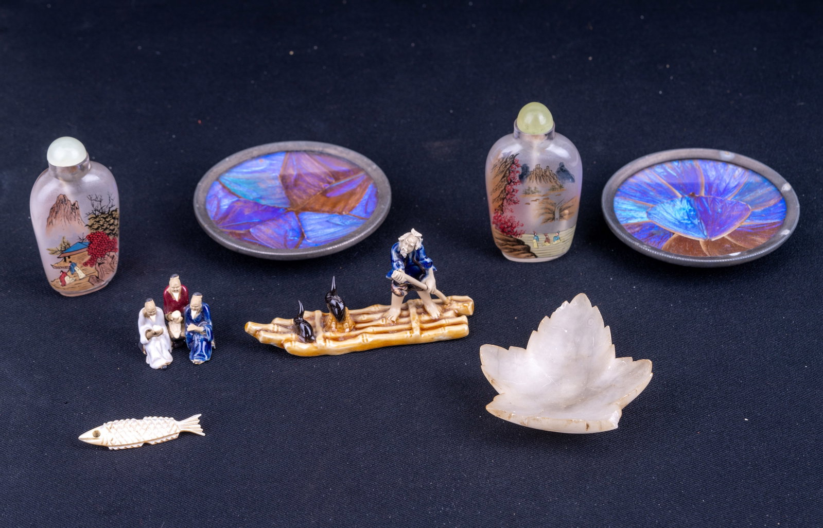 Reverse Painted Snuff Bottles, Butterfly Wing, +: Grouping includes two Chinese reverse painted snuff bottles, two butterfly wing ash trays/pinch bowls measuring approx. 3.5" in diameter, a leaf shaped stone ashtray, M.O.P fish pin, and two Asian por