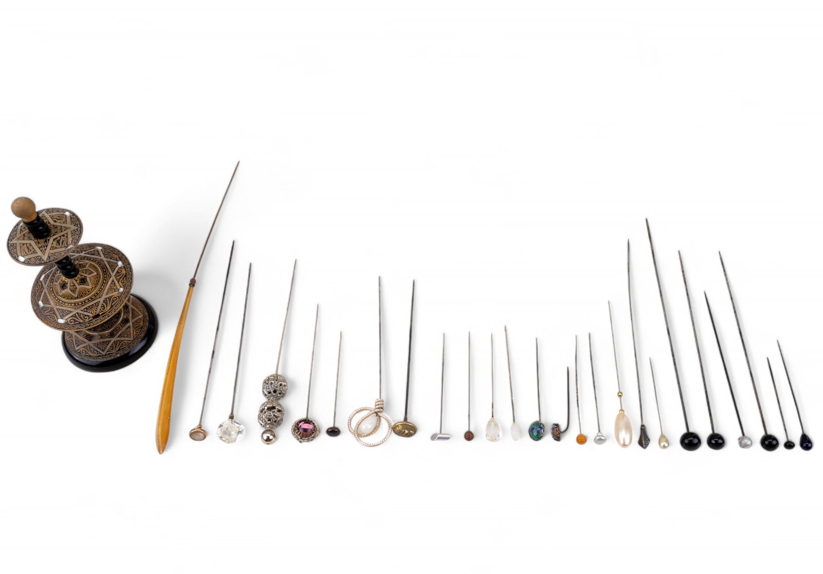 Antique Victorian Hat Pins & Damascene Holder (26): 25 Antique hat pins - largest measures approx 9.5" L; materials include: glass, faux pearl, brass, rhinestones, semi precious stone, crystal, filigree, and bone. 1 antique Damascene duel bevel hat pin