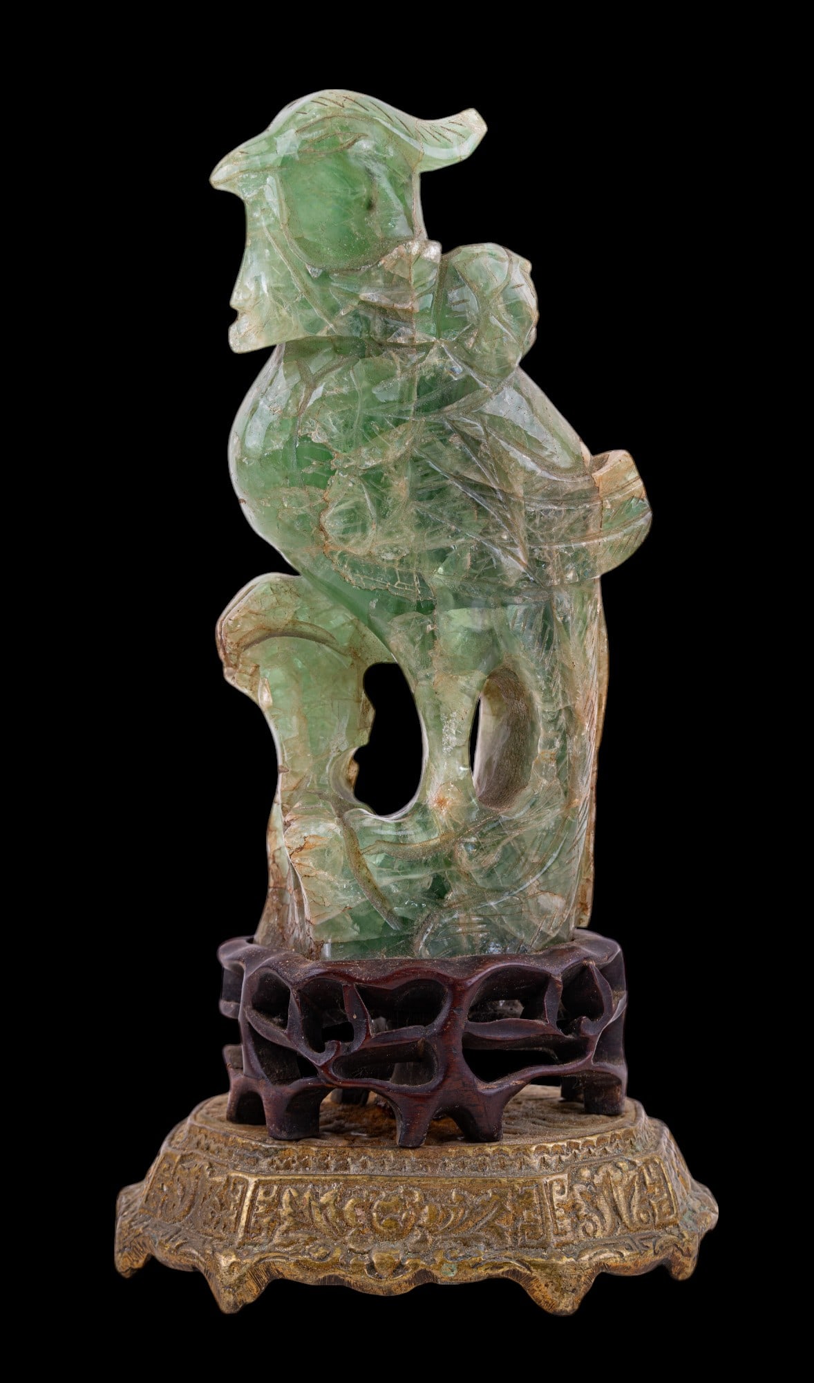 Antique Carved Green Flourite Bird on Stand: A carved green fluorite (tests for hardness of jadeite) bird on wooden & brass pedestal, measuring approx. 11.25" tall (stone carving is approx 8" tall). Bird could be cleaned. Underside of stand show