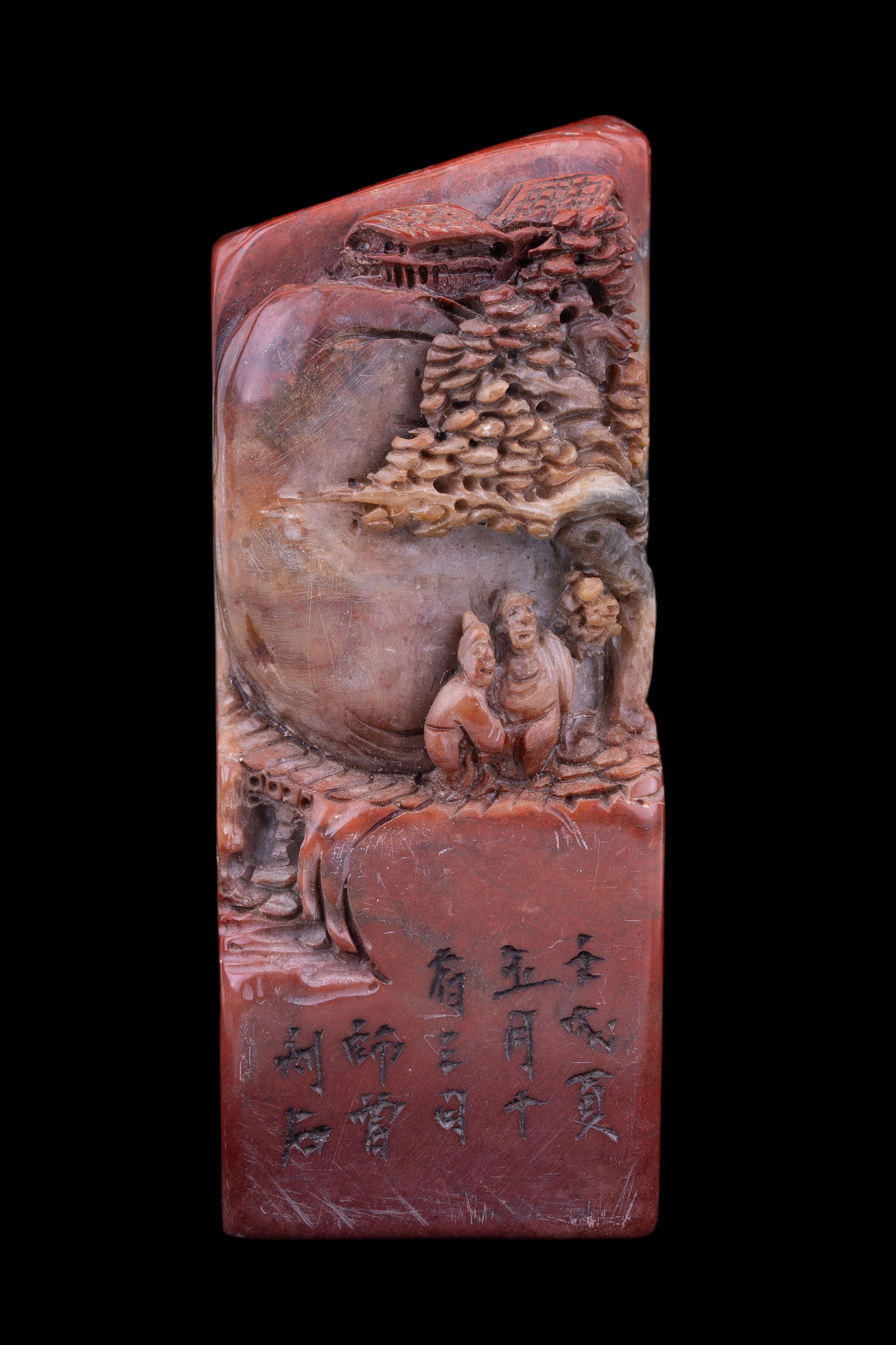 Chinese Shoushan Stamp: Carved Chinese Shoushan stamp in a red to brown colored stone depicting scholars in a mountain landscape measuring approx 4" H, there is writing etched on the front. Stamping surface approx 1.75" squa