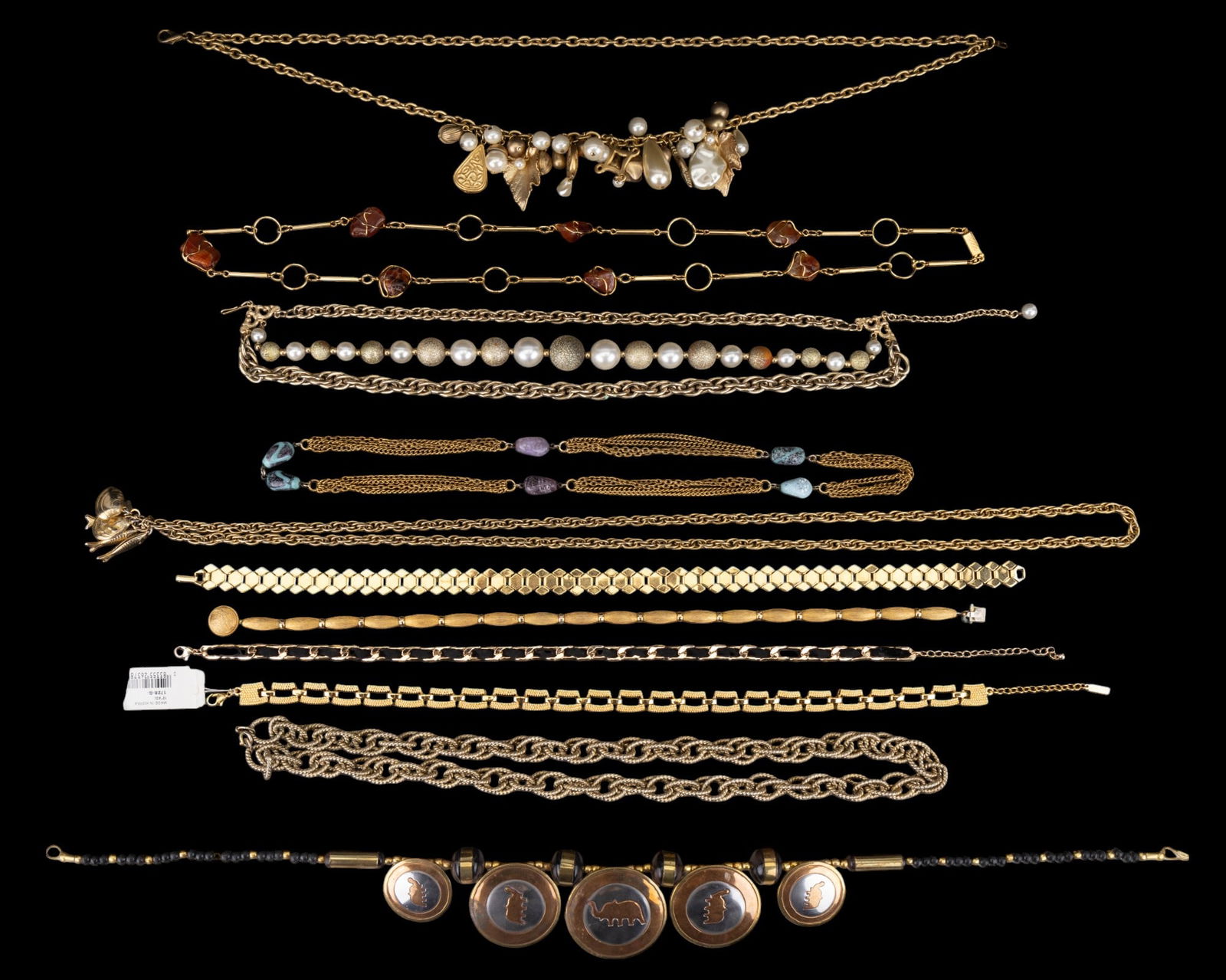 Gold Tone Necklace Grouping (11): 11 various gold tone necklaces, some w/ stone accents. some w/ beads, & some w/ pendants (see photos). Beaded necklace w/ 5 elephant pendants measures approx. 23.5" long.