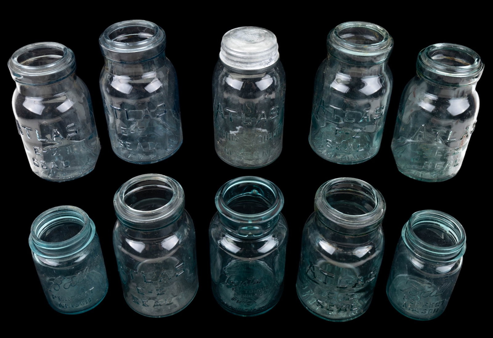 Vintage Atlas and Ball Jars: An assortment of vintage and antique Atlas EZ Seal jars and Ball Mason Jars, ten in total.