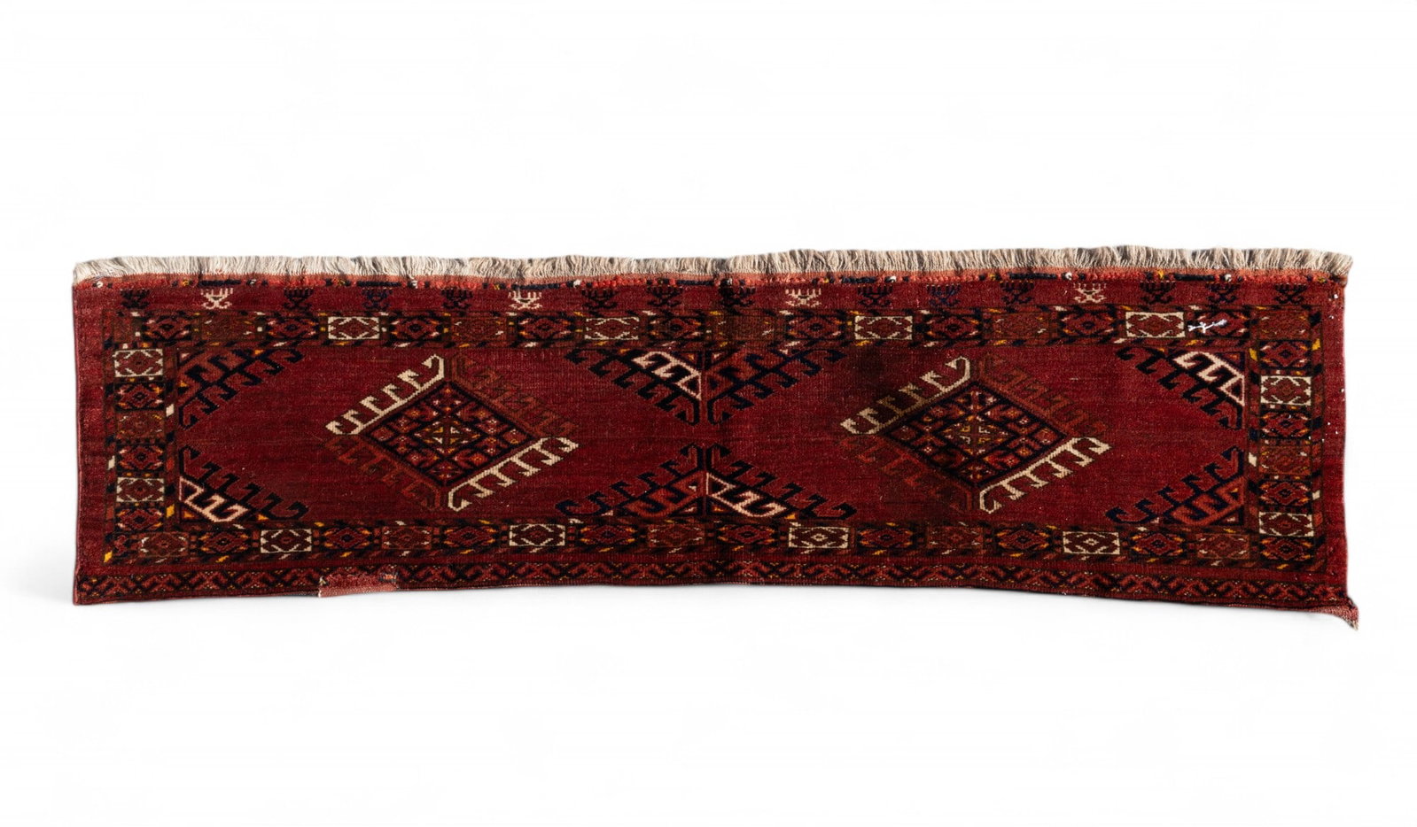Turkoman Rug: Turkoman rug approx. 1'3" x 5'4" w/ crimson, orange, brown, black, & cream / ivory patterns w/ geometric motifs. *All rugs / carpets are used & come from fine estates. Keystone Auctions does not clean