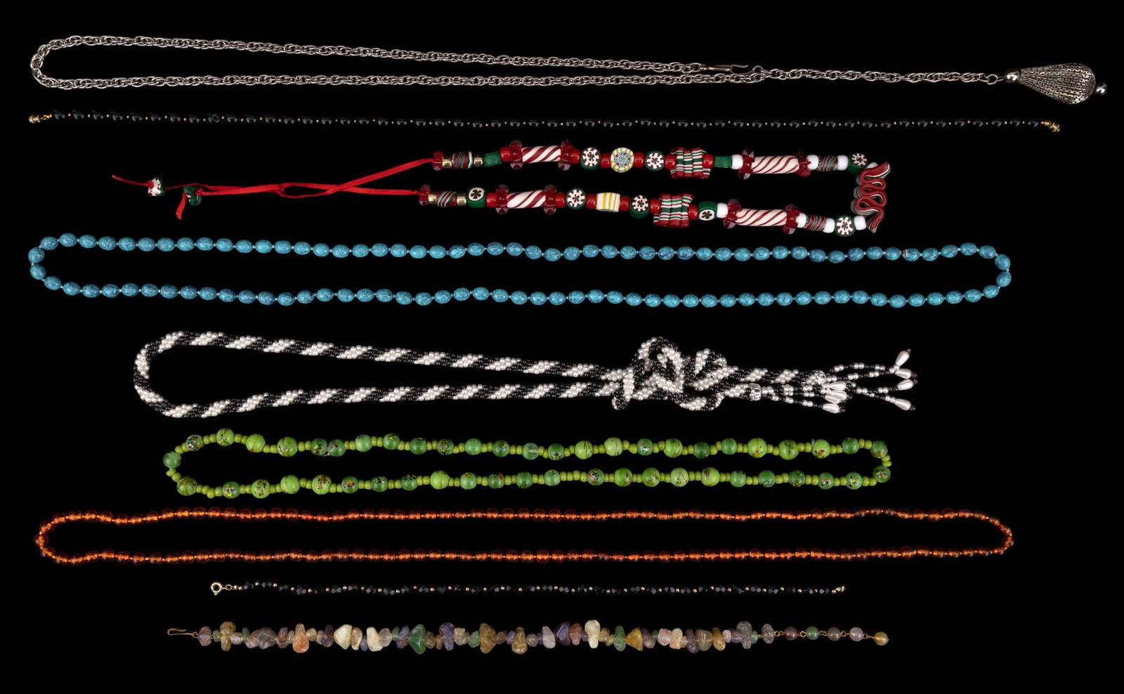 Beaded Necklaces: A collection of costume beaded necklaces featuring a polymer clay bead Christmas necklace, black and white faux pearl twist tie style with no clasp, faux rough chunky stone necklace, faux turquoise be