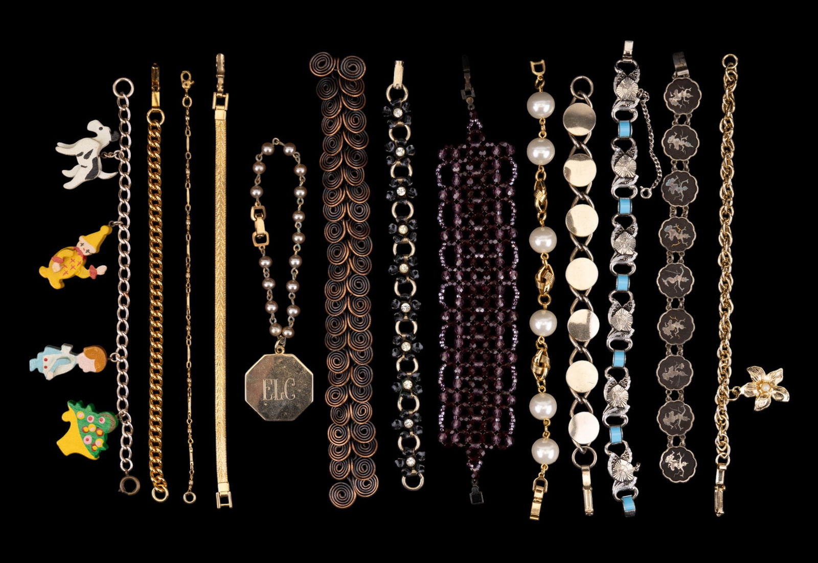 Vintage Bracelets: Vintage Coro monogrammed pendant on a faux pearl and metal chain, Naper flat braid tennis bracelet, and an assort ment of bracelets featuring a faux pearl and gold tone twist, black enamel flowers wit