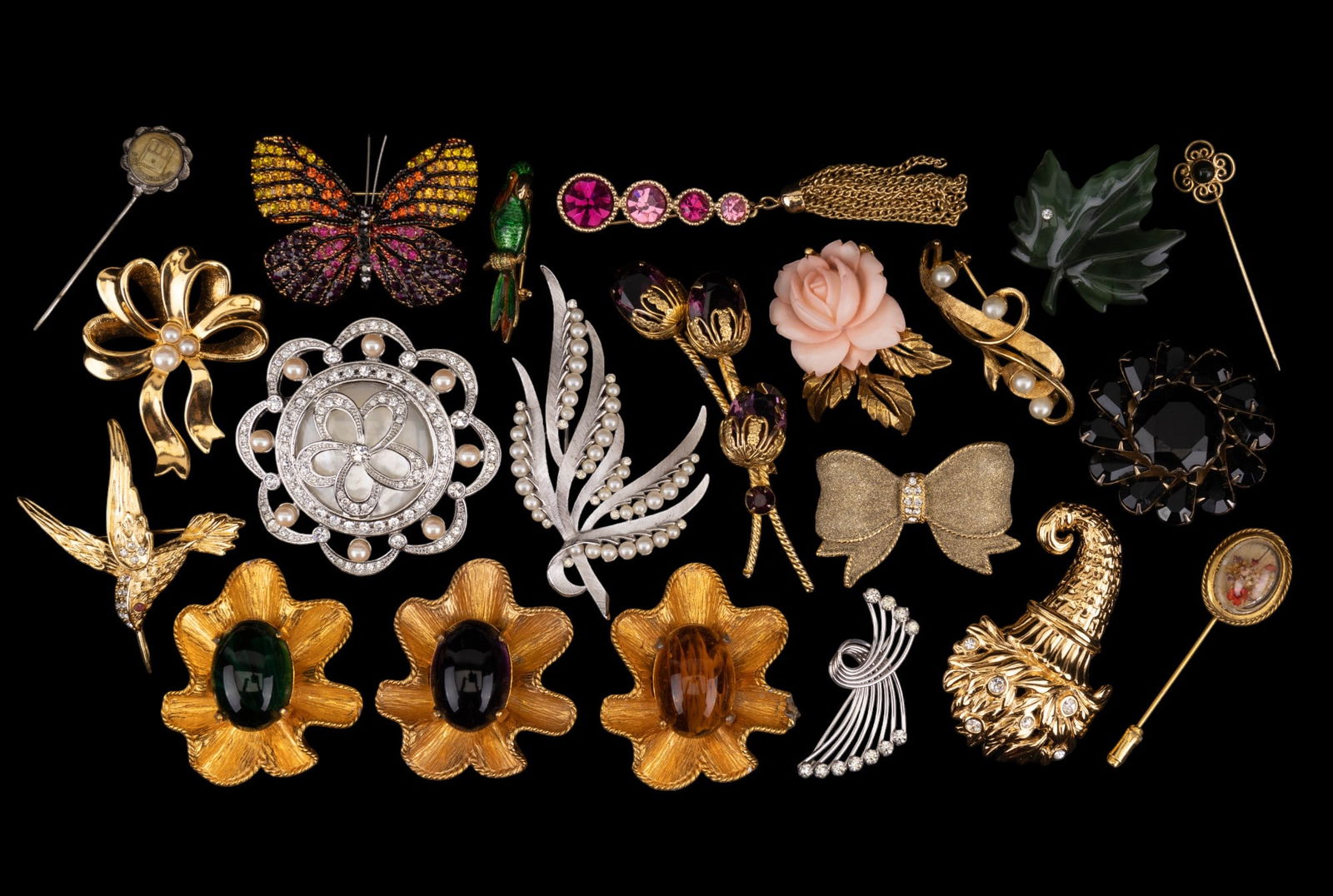 Vintage Desginer Brooches: An assortment of vintage brooches with rhinestones, faux pearl, carved natural material, acrylic resin, enamel, cabochan stones, and dried flowers from designers such as Monet, Sarah Coventry, Trifari