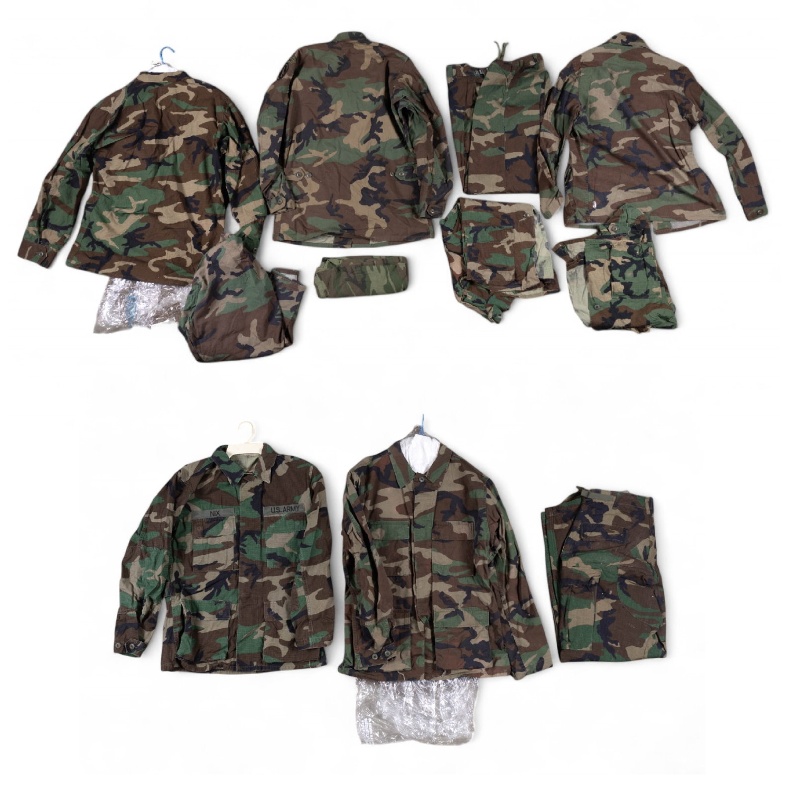 US Army Fatigues: Eight US Army fatigue jackets some with Captain, Honor Guard, Paratrooper, and Infantry insiginia, two pairs of fatigue pants, and one camouflage t-shirt. Sizes range from small to medium.