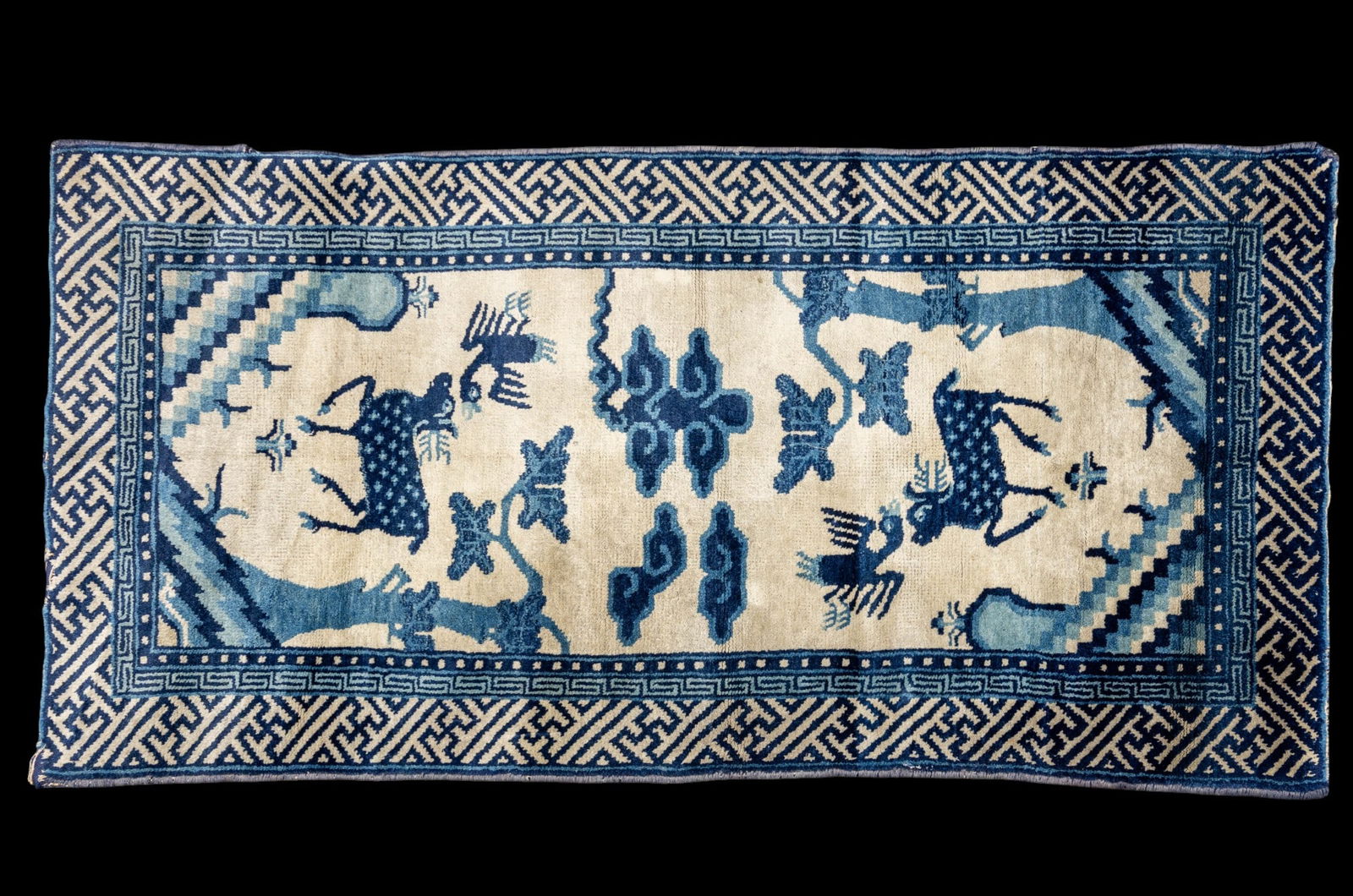 Antique Chinese Rug: Antique Chinese rug approx. 2' x 4' w/ navy blue, royal blue, livid bluish-gray, & ivory patterns w/ geometric, animal, & botanical motifs. Some edge loss. *All rugs / carpets are used & come from fin