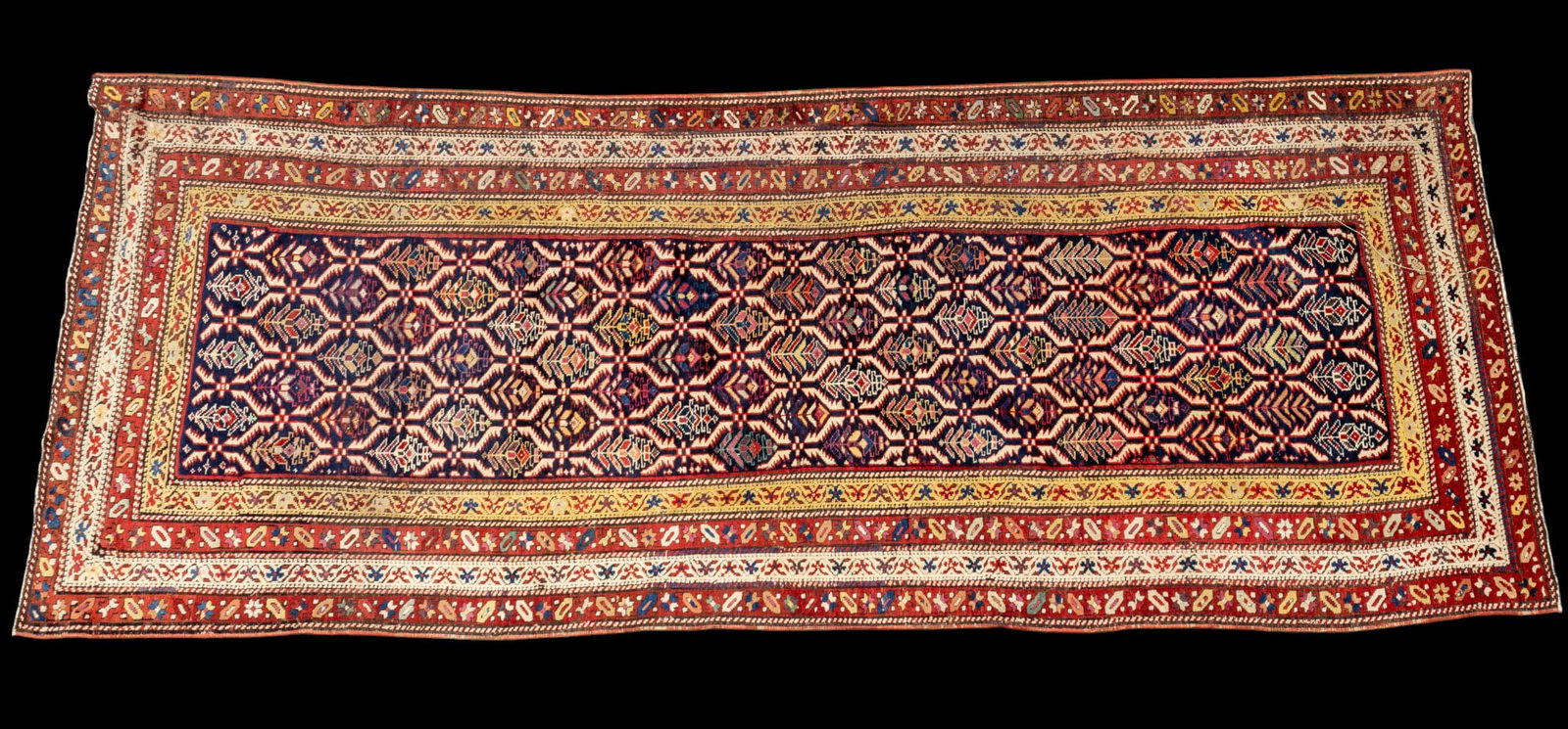 Antique Kazak Runner: Antique Kazak runner rug approx. 3'4" x 8'10" w/ red, magenta, pink, purple, blue, livid bluish-gray, green, sage green, gold, tan, brown, & ivory patterns w/ floral motifs. *All rugs / carpets are us