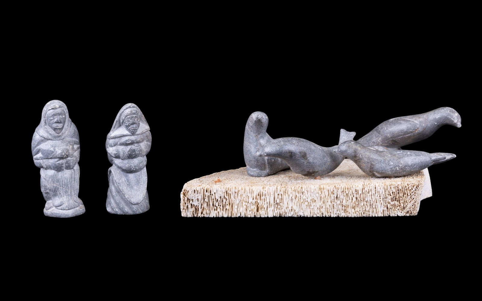 Inuit Stone Seals on Bone Base Sculpture: Inuit sculpture of stone seals & hunters housed on a porous bone base. Presumed to be whale bone. Note: Some sculptures are loose on base, some have loss to some of or all of a wooden peg.