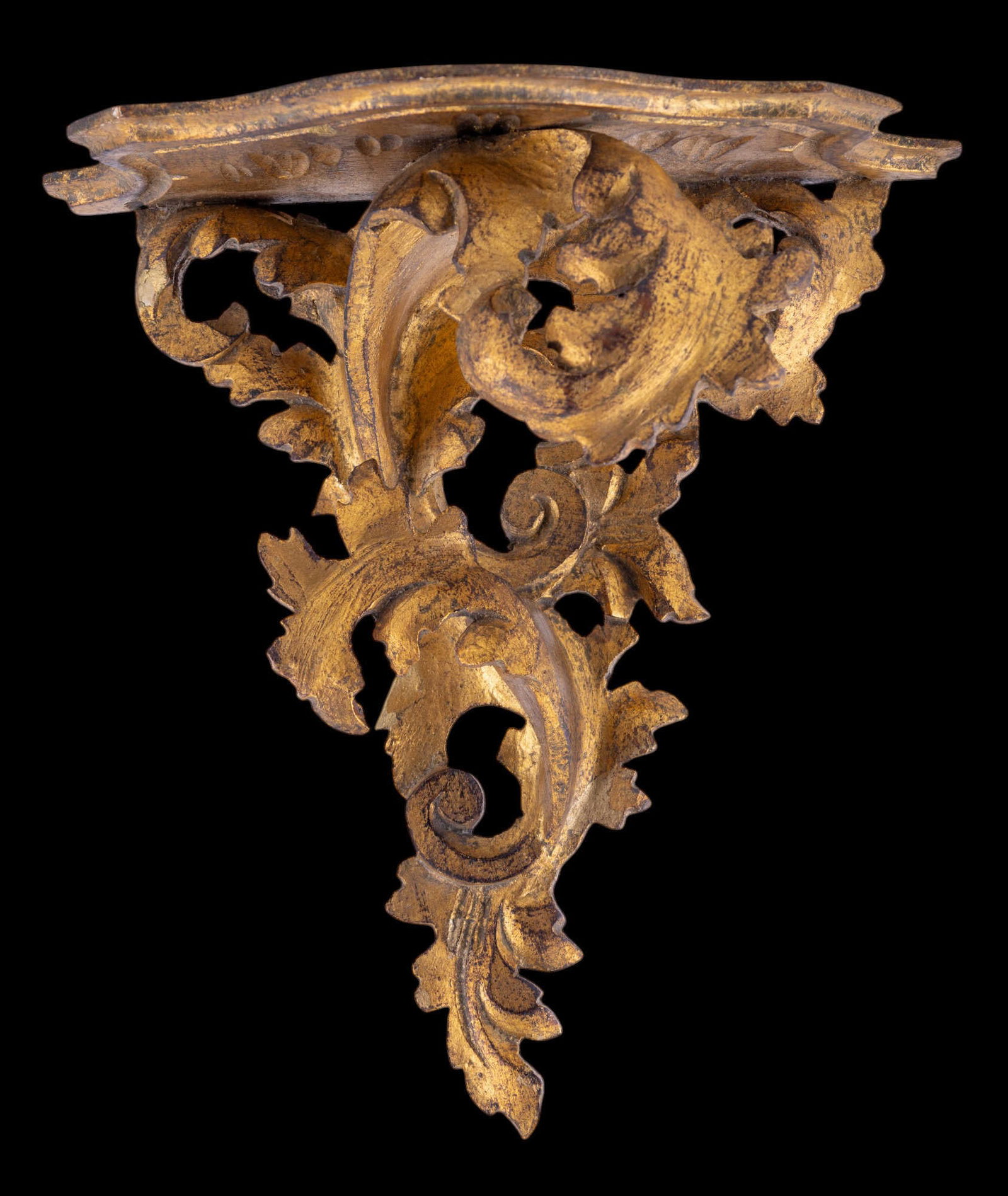 Early 20th C Italian Giltwood Shelf: An early 20th century Italian giltwood shelf with an intricate leaf motif. Some wear/damage to gilding consistent with age, as seen in photography. Measures approx. 11" tall, 10.5" across at top, 5.5"