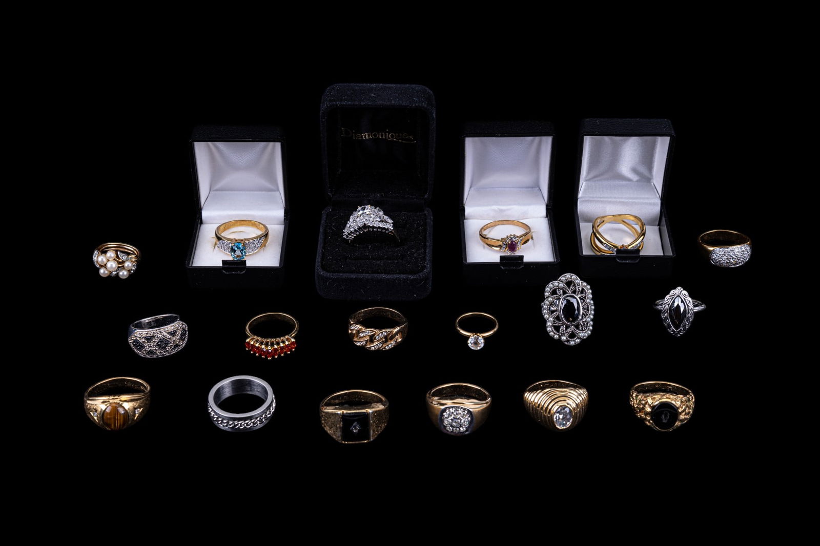 Gold Electroplated Large Size Costume Rings: An assortment of 18 large size costume rings featuring a tiger's eye mens ring 14K GE, stainless steel chain ring, onyx 14K GE, rectangle onyx 14K GE, raised oval rhinestone ring 18K HGE, rhinestone c