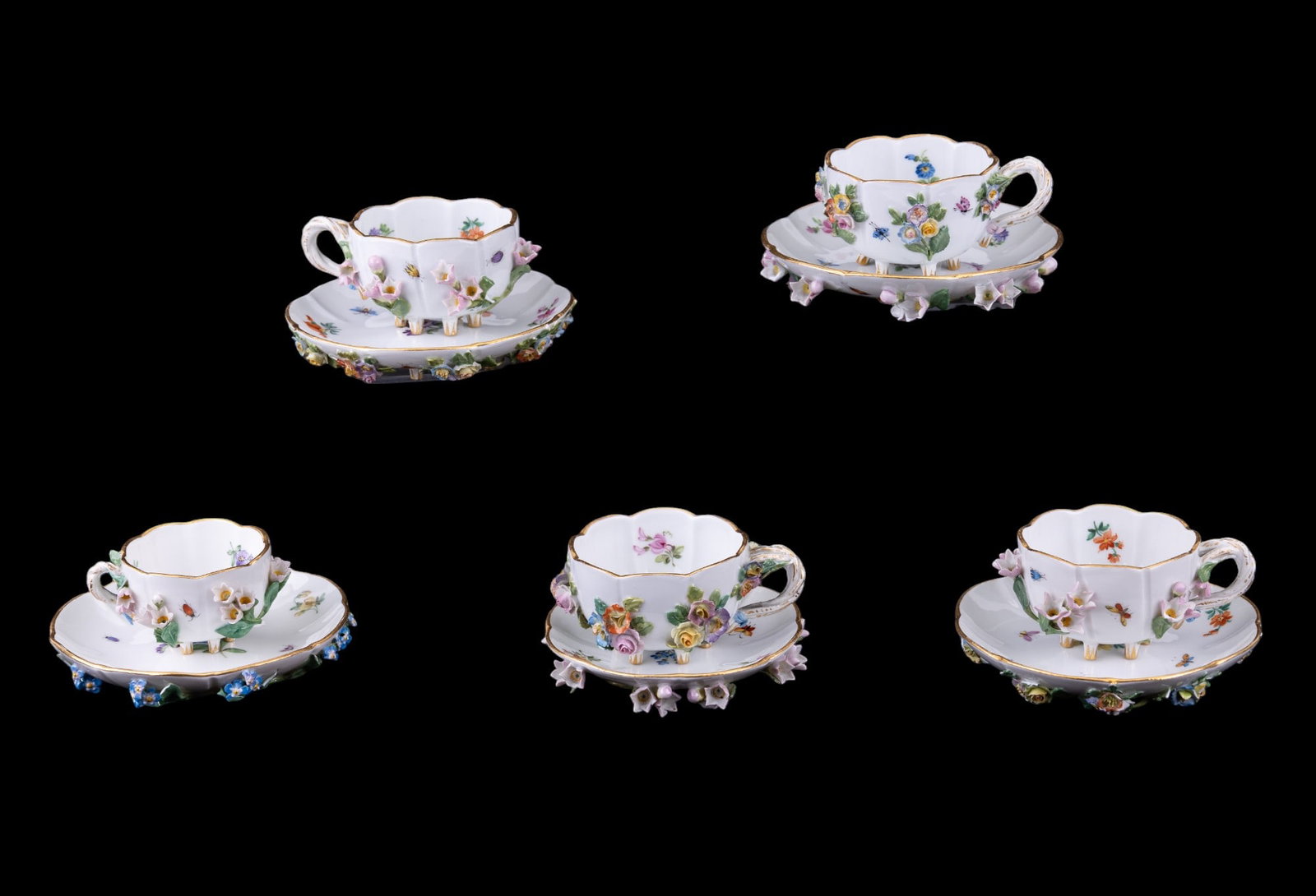 5 Meissen Floral Applique Tea Cups and Saucers: Set of 5 Meissen porcelain teacups & saucers w/ multi color floral applique encrusted designs. Some minor loss to flower accents. 4 saucers measure approx. 5" in diameter. The last saucer is smaller,