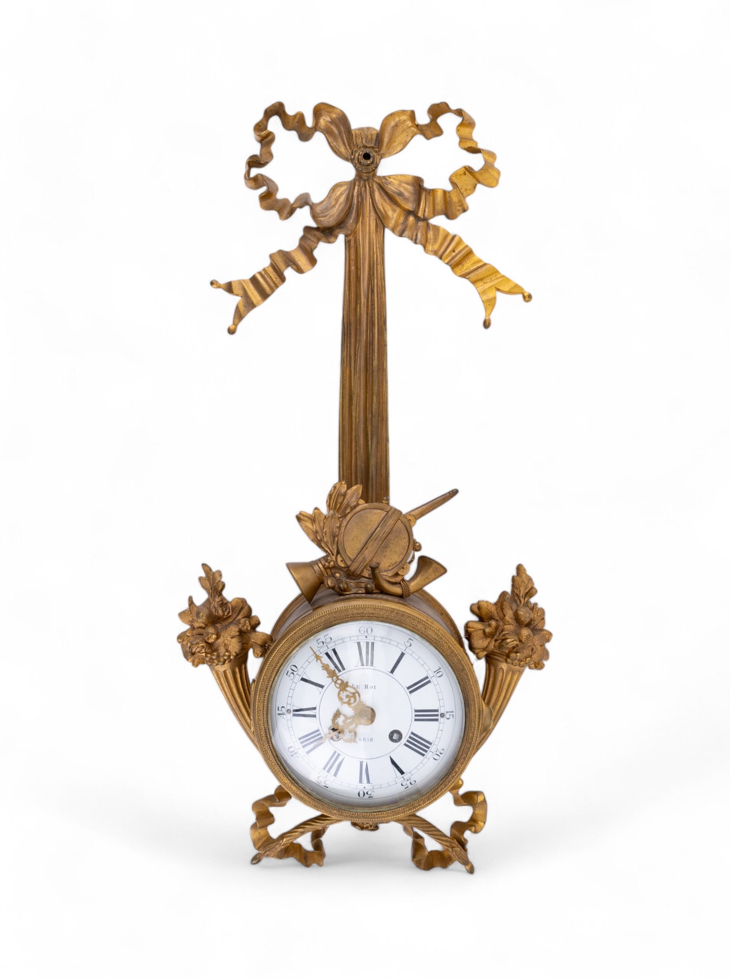 French Le Roi Gilt Bow Top Cartel Wall Clock: French Le Roi Paris gilt clock. There is some damage towards the bottom (see photos) with the side decor loose with repair at bottom center and wire support on sides. Clock is approx. 20" long & has n