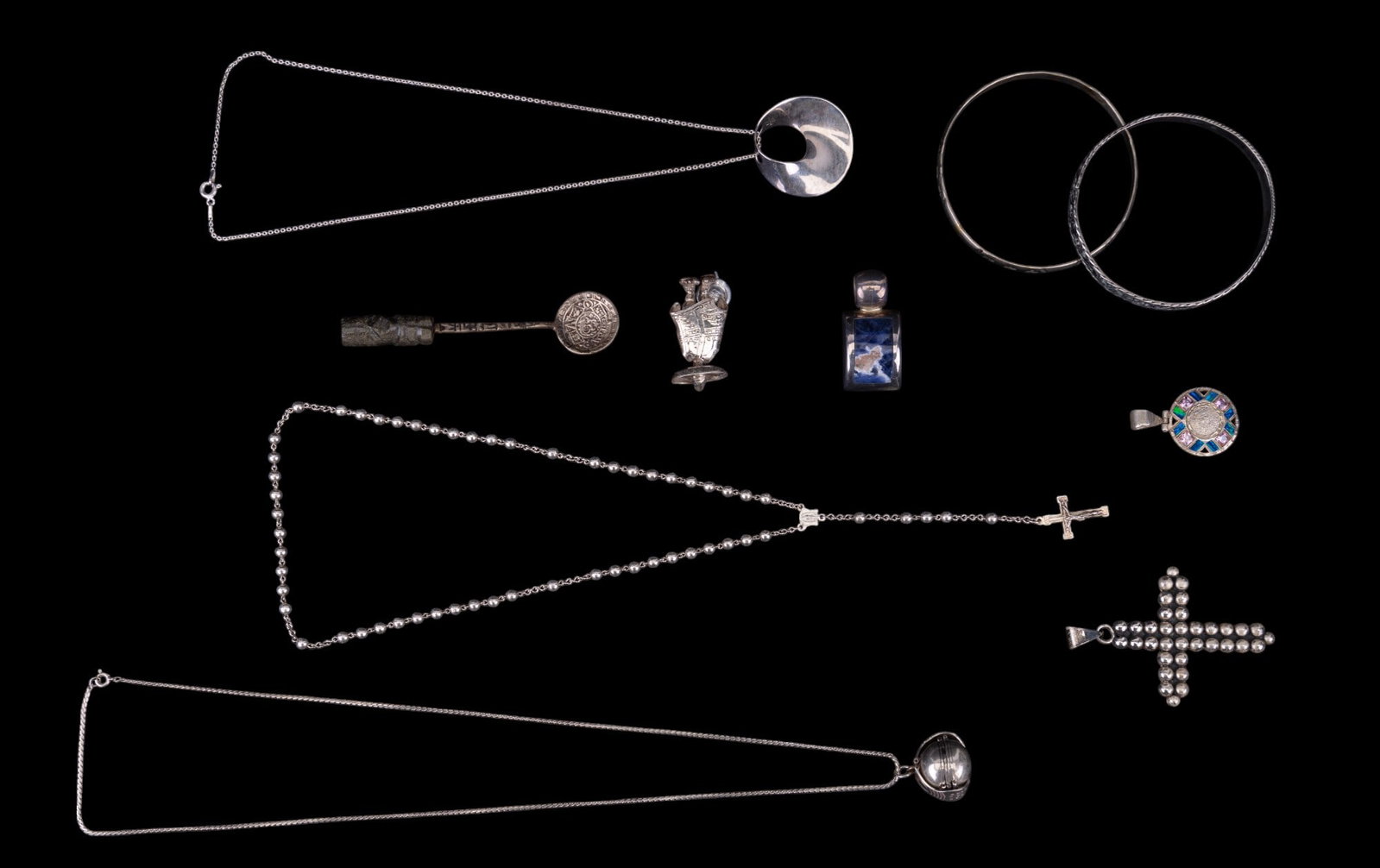 Mexico Sterling Necklaces, Bangles, Spoon & Brooch: Grouping of sterling silver .925 jewelry from Mexico, including a vaquero (cowboy) brooch, 2 different bangle bracelets, a Taxco folding ball pendant necklace w/ etched design on the interior panels, 