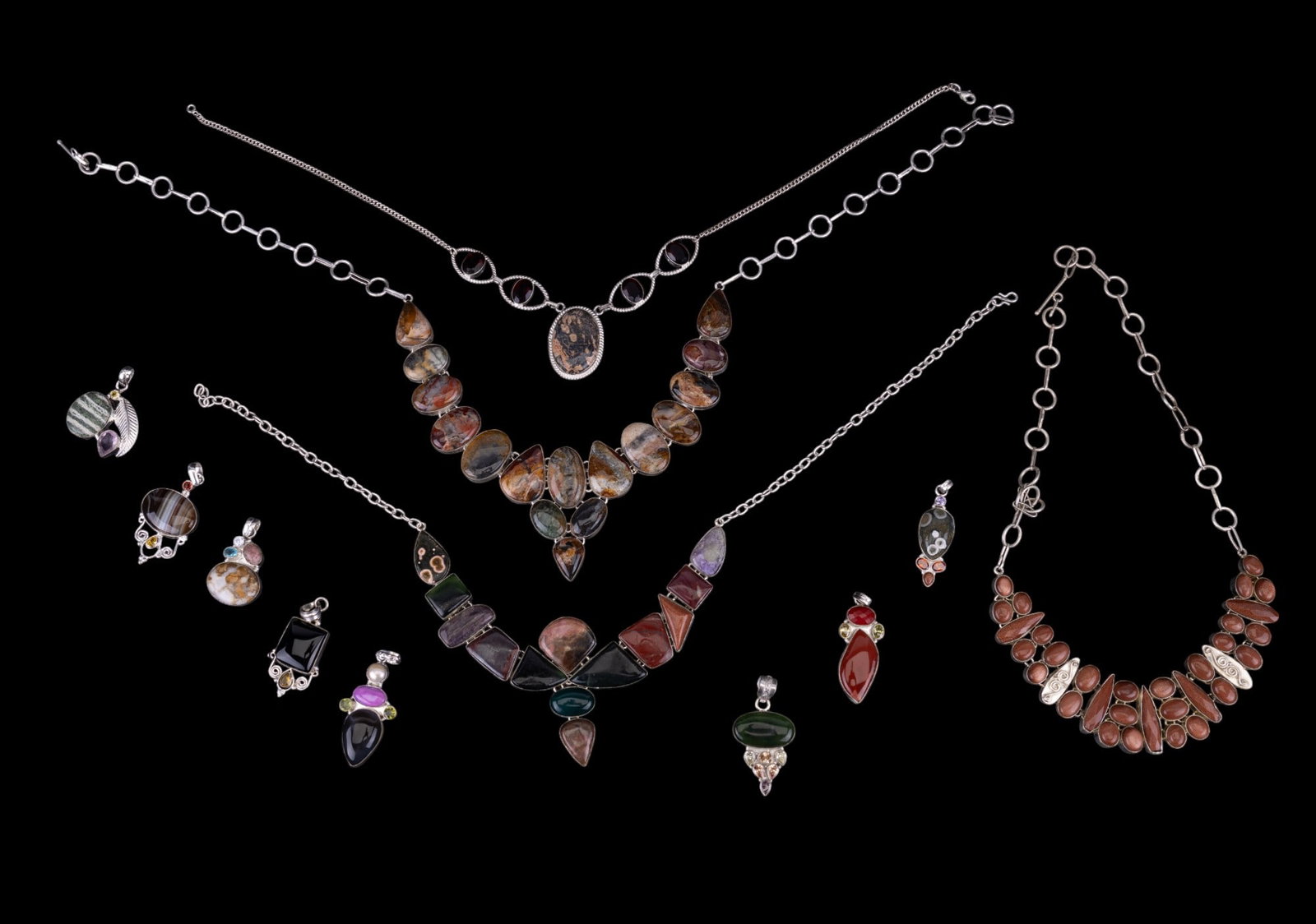 Multi-Stone Earth Tone Silverplate Jewelry: Grouping of multi-stone earth tone silverplate jewelry. There are 8 loose pendants & 4 necklaces. Stones include different types of jasper, red goldstone / sandstone, agate, & more. Leopard skin jaspe