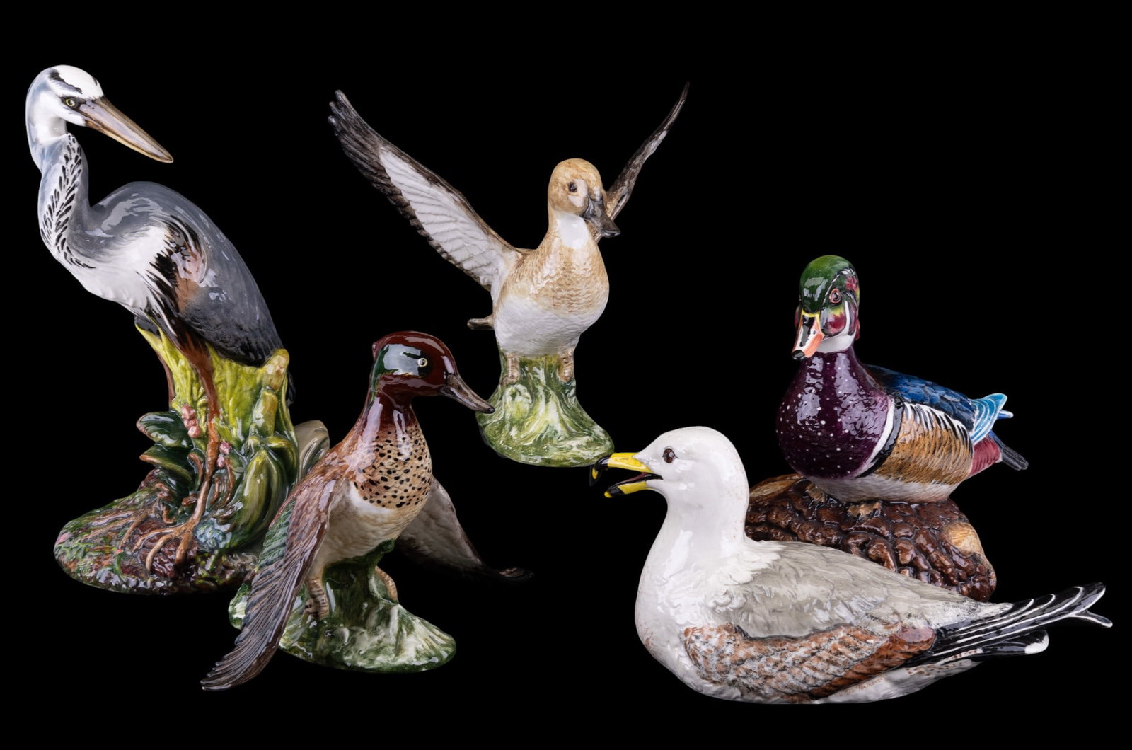 Townsend's Glazed Ceramic Bird Statuettes: A collection of five Townsend's ceramic bird statuettes featuring a seagull, 15", a blue heron, 9x16.5", wood duck drake sitting on a log12x12x11", wood duck female with spread open wings 12x12x12", a