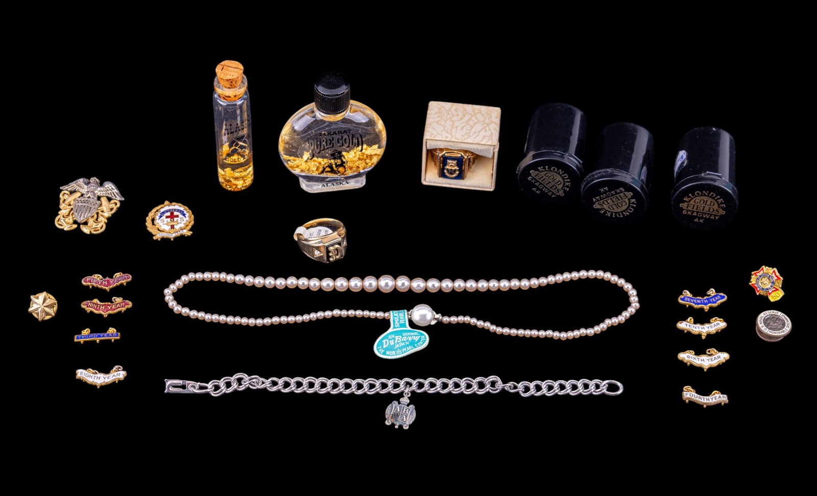 10K Gold Ring, Alaskan Souvenir Gold, & More: 3 containers of Alaskan souvenir gold, each containing approx. 1.7 grains, as indicated by the labels; 2 containers of gold in water (unknown quantity of gold), sterling silver WWII Navy hat insignia,