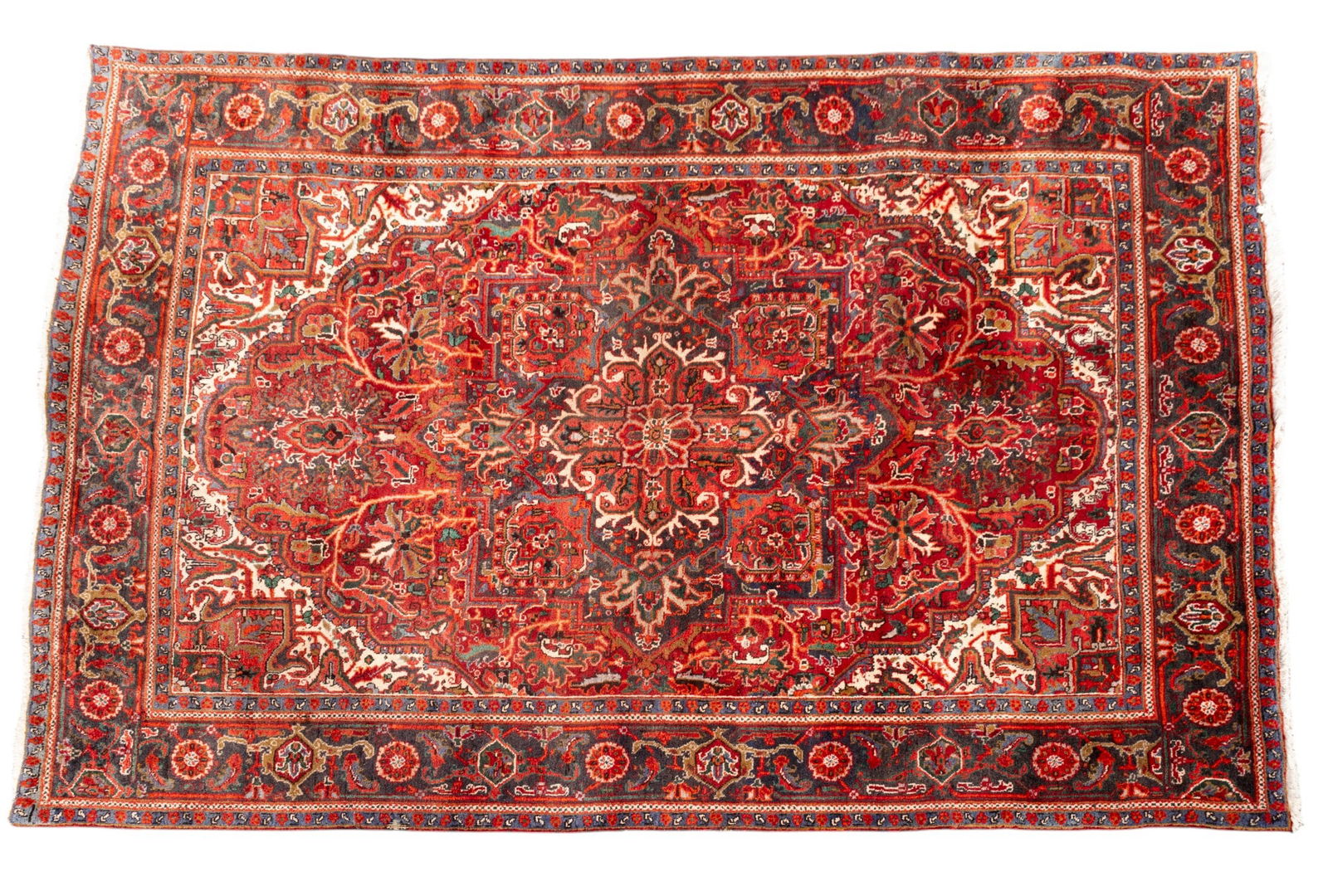 Persian Heriz Rug: Persian Heriz rug approx. 7'9" x 10'10" w/ red, orange livid blue-gray, navy blue, green, brown, tan, & ivory patterns w/ floral motifs. *All rugs / carpets are used & come from fine estates. Keystone