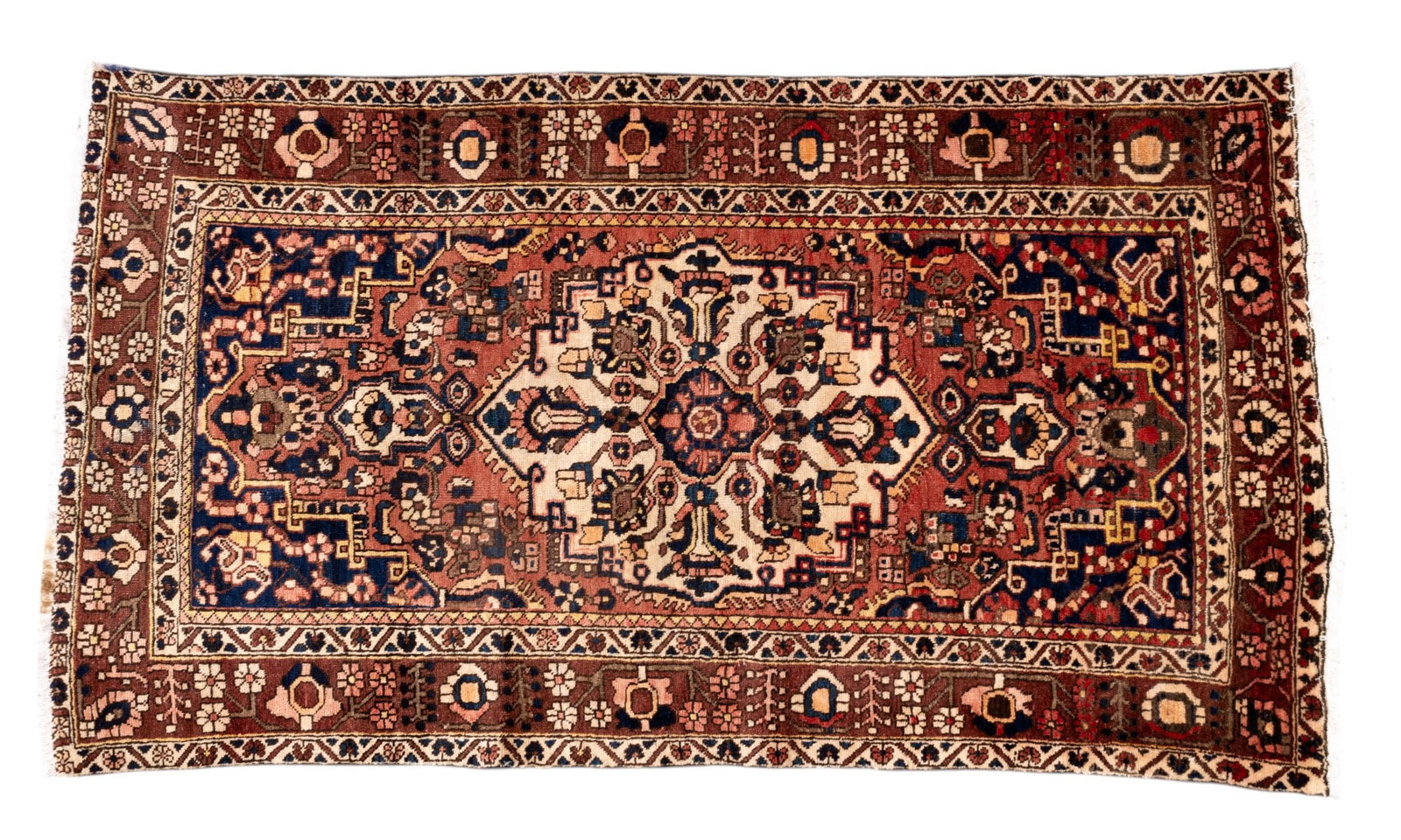 Persian Heriz Rug: Persian Heriz rug approx. 4'11" x 8'8" w/ clay red, dull pink, dark blue, brown, tan, & ivory patterns w/ floral motifs. *All rugs / carpets are used & come from fine estates. Keystone Auctions does n