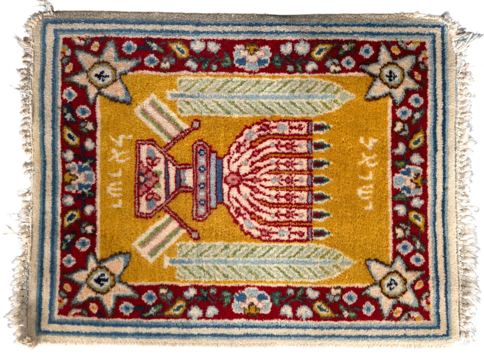 Judaic Hand-Knotted Wool Mat with Menorah Design: Judaic hand-knotted wool mat featuring a vibrant design that includes a central menorah motif, Hebrew script, and decorative floral and Star of David patterns. The mat measures 17.5 x 23 inches and is