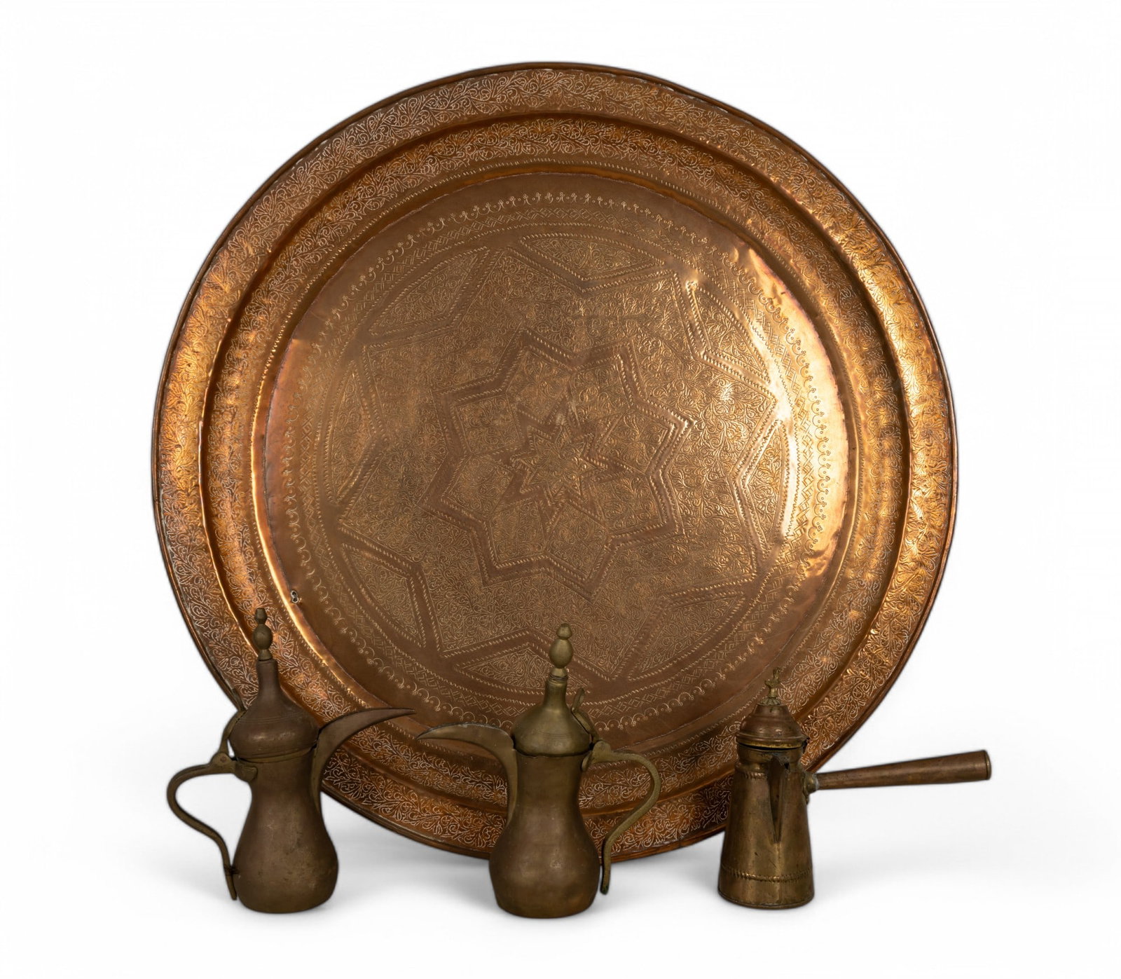 Large Brass Charger w/ Arabic Dallah Coffee Pots: Large brass charger with engraved floral and star designs measuring approx. 34" Dia. 2 brass Arabic Dallah coffee pots and 1 Turkish coffee pot with bird motif ranging from 9.5" H to 12" H.