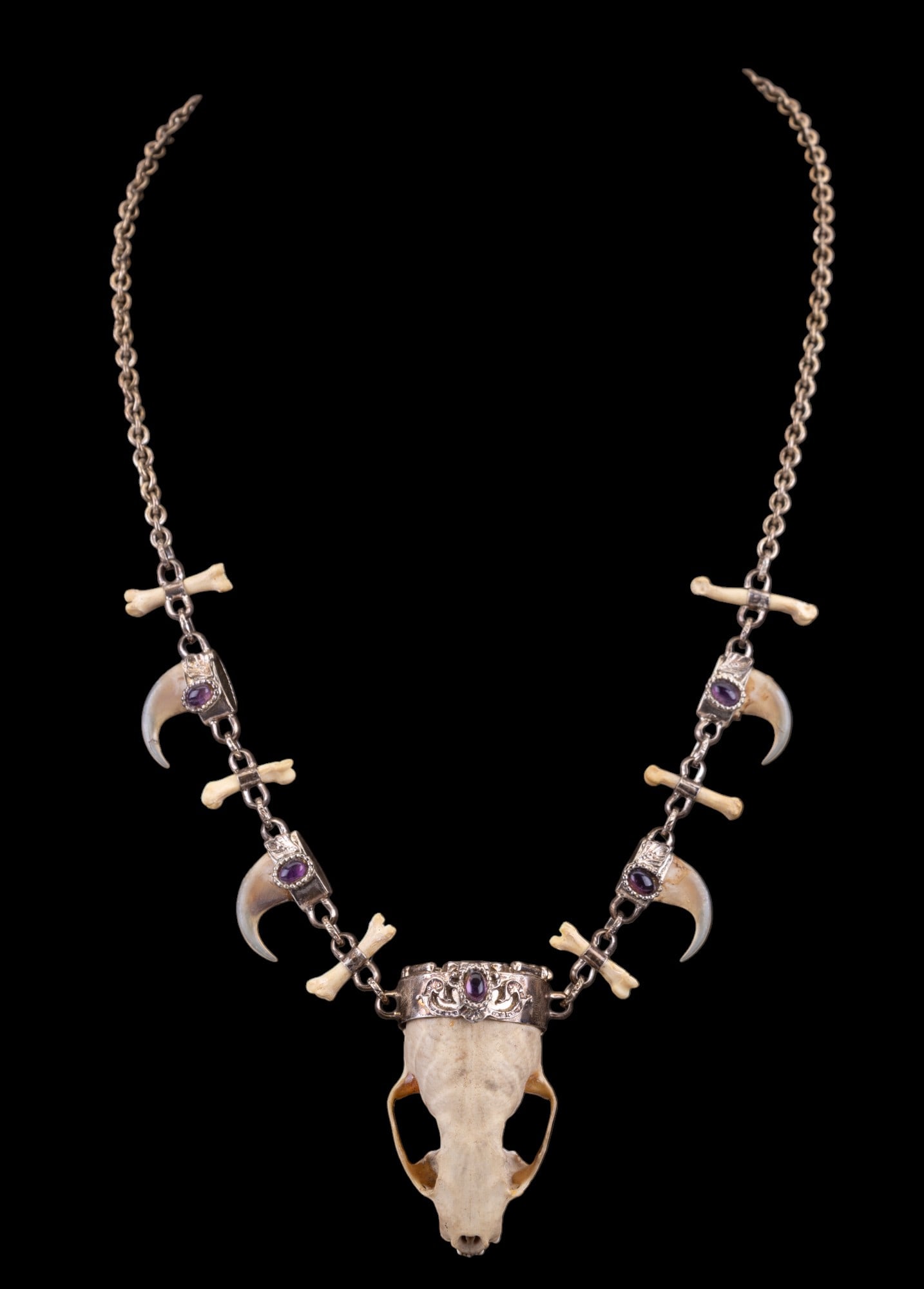Sterling Necklace with Animal Teeth and Nails: Sterling necklace with animal teeth, nails, and and violet accent stones measuring approx. 20" L.