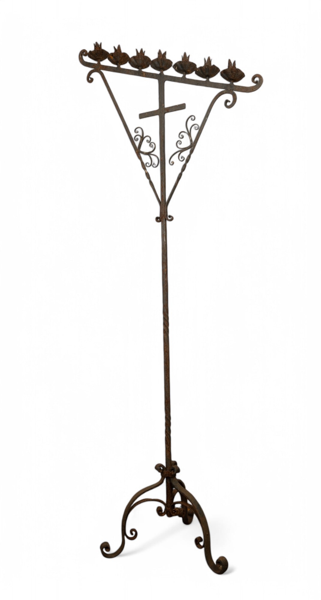 Large Iron Church Candelabra: Large ornate floor standing wrought iron church candelabra with a Holy Cross in the center and seven spots for taper candles, tilted at an angle, note heavy rust due to use and age. Feet width measure