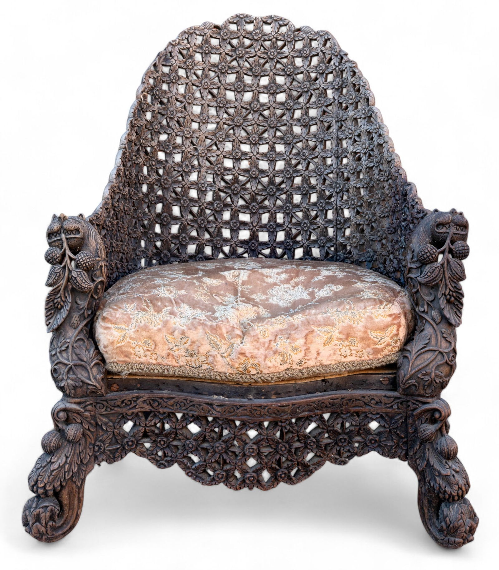 19th C Burmese Carved Chair w/Tiger Armrests: Heavily / all carved Anglo-Indo Pacific armchair w/ tiger figures on each armrest and floral and fruit motifs. Carved body looks like a lattice of flowers. The detail on the tiger teeth is very fine.