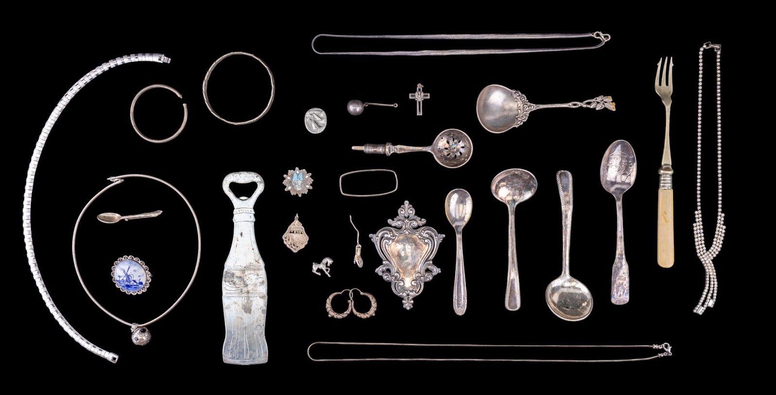 Unmarked Silver Plate and Silver Tone Jewelry: An assortment of EPNS vintage spoons and fork, unmarked silver tone necklaces, charms, hoop earrings, hammered bangle bracelet, Towle salt spoon brooch, Delft brooch, pendants, herringbone chain 22" a